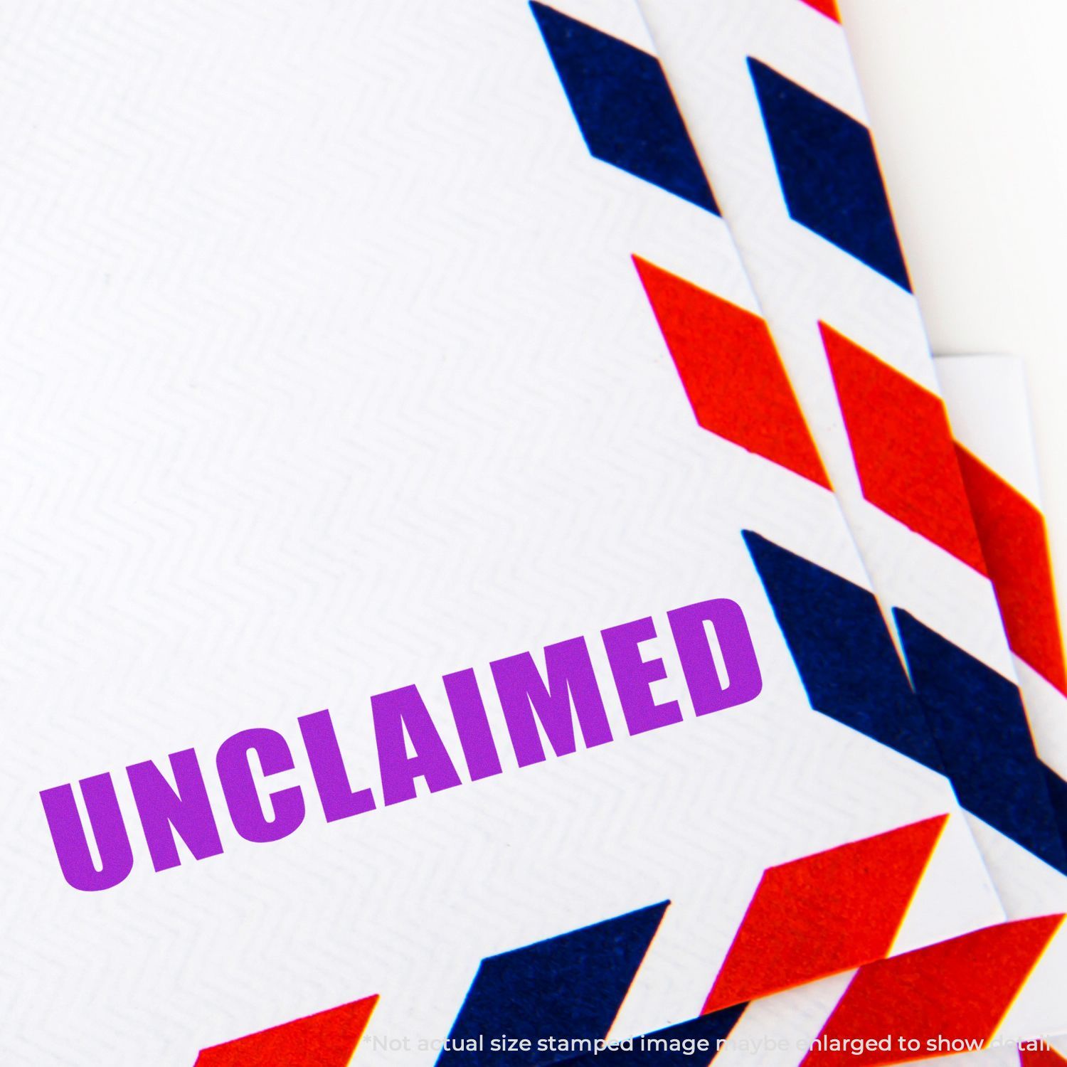 Unclaimed stamped on a white envelope with red and blue airmail border, close-up of undelivered mail notice.