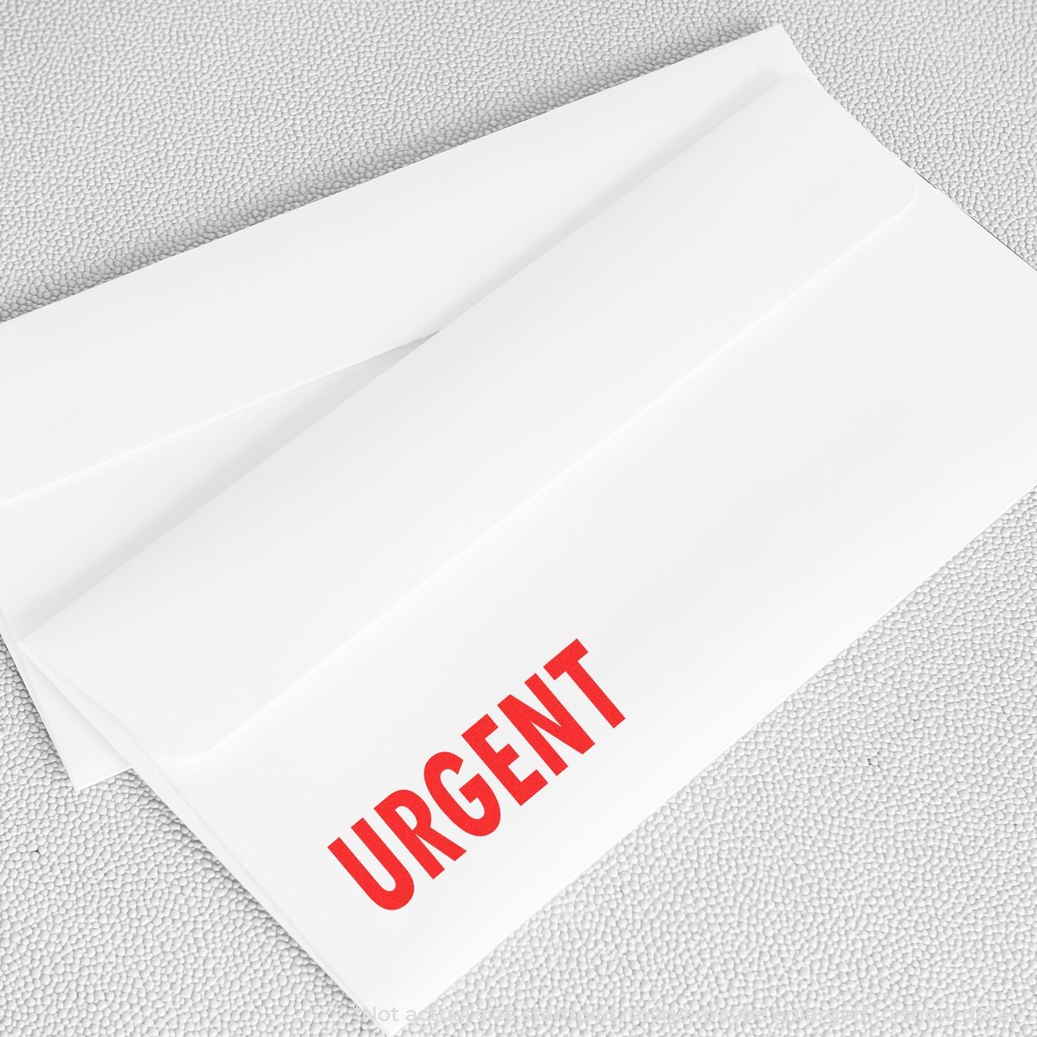 White urgent envelope with red URGENT text on textured background, business mail concept.