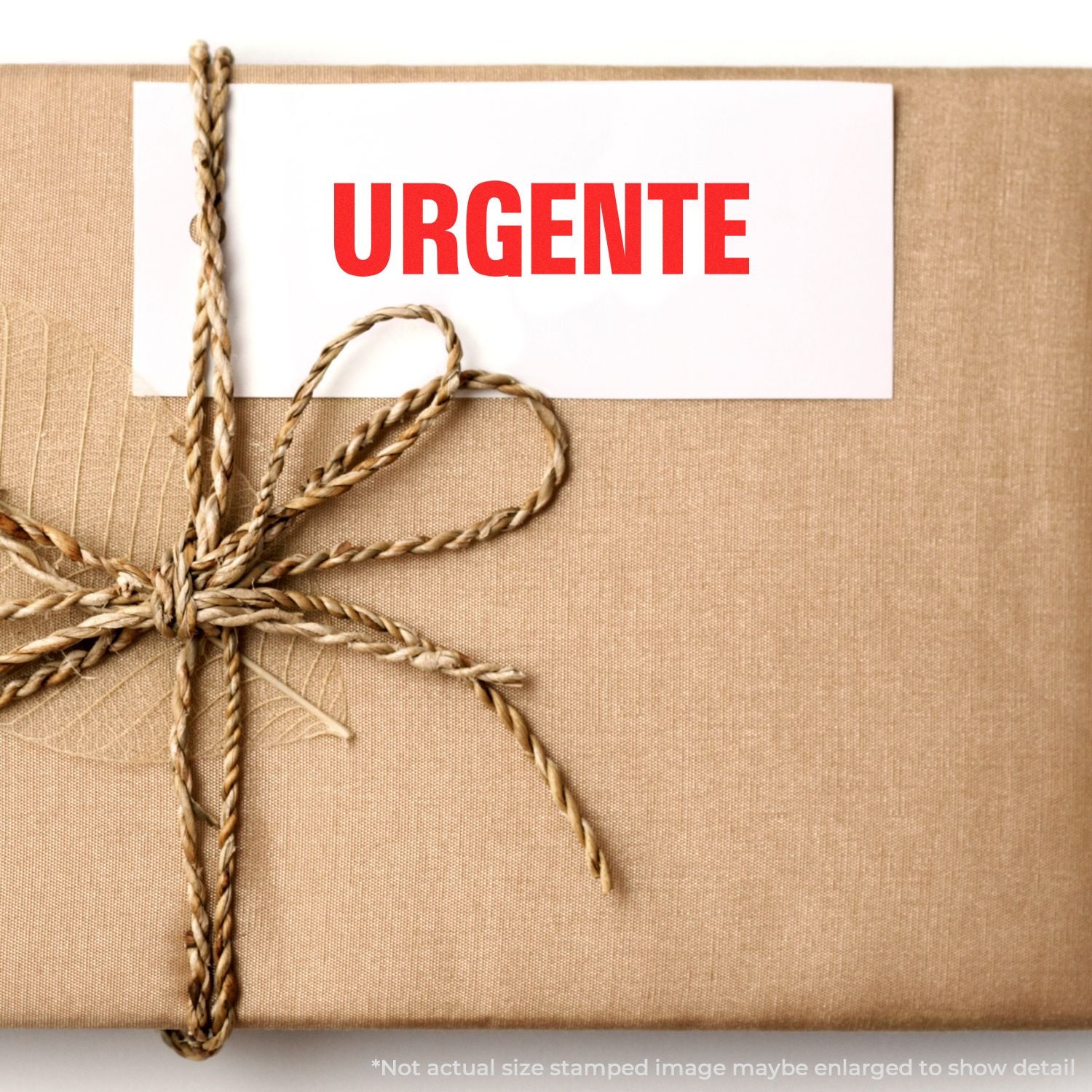 Kraft paper gift box wrapped with twine and a red URGENTE label, indicating an urgent delivery.