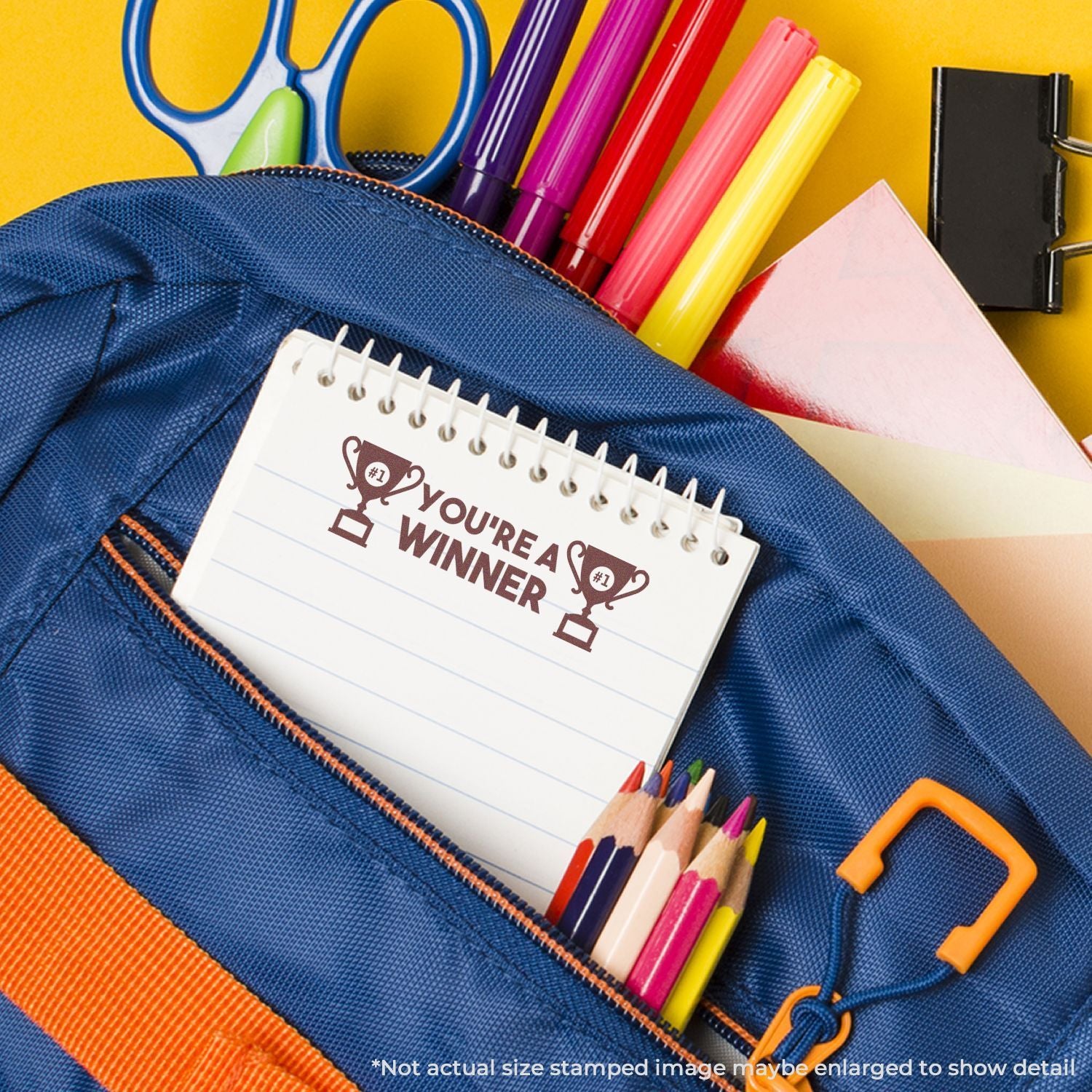 Colorful school supplies in a blue backpack with notebook, pencils, markers, scissors, and clip on a yellow background