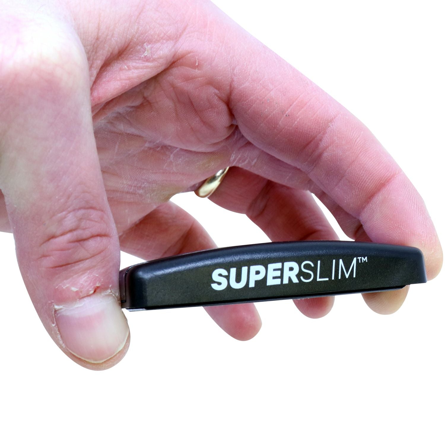Hand holding a black SUPERSLIM compact electronic device on a white background.