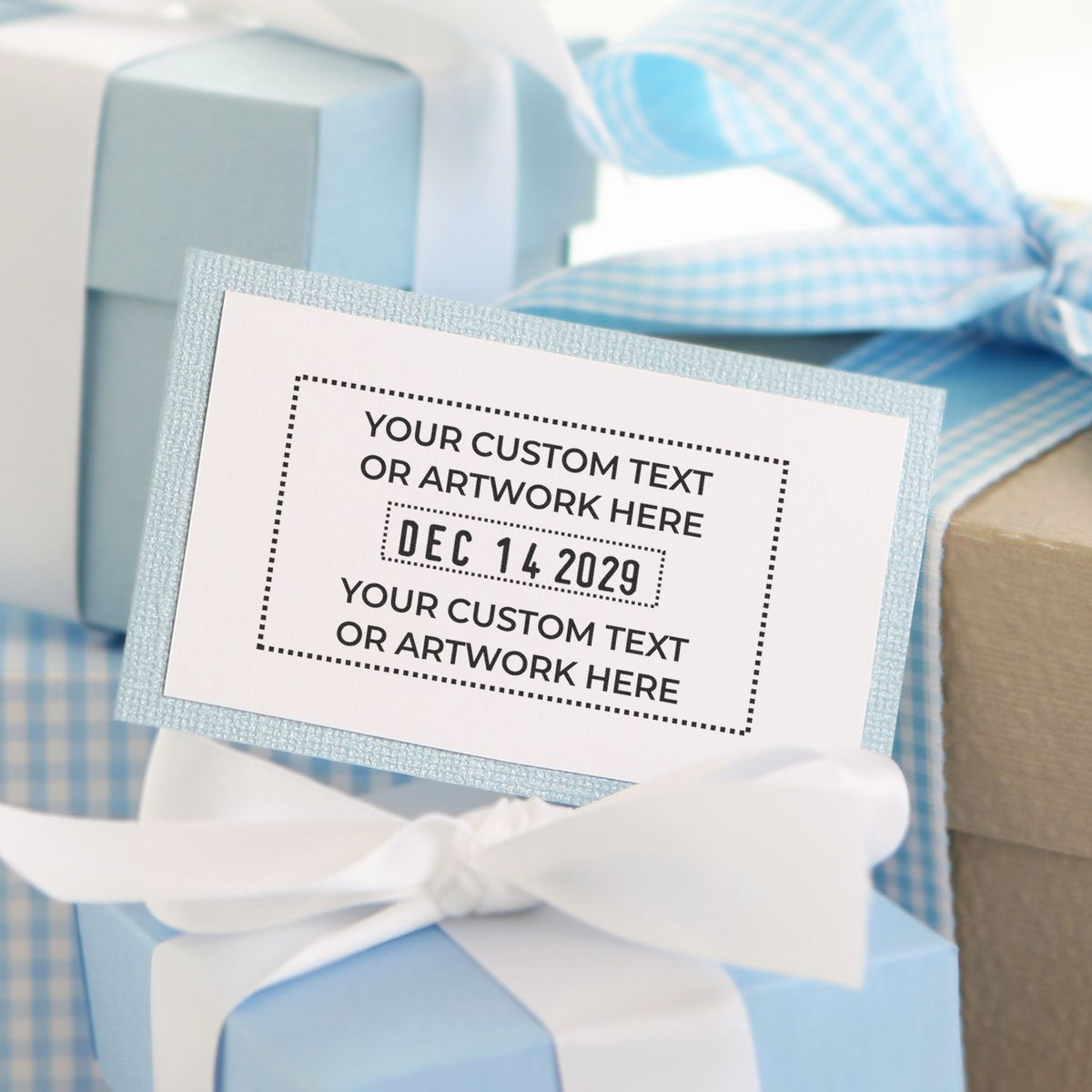 Blue baby shower gift boxes with white ribbon and personalized custom tag card.