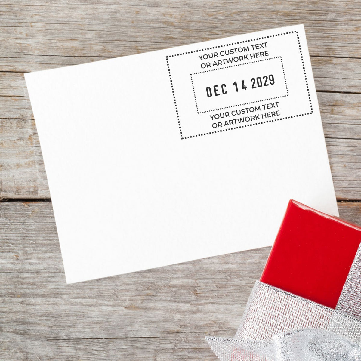 Blank customizable postcard mockup with date stamp, on rustic wood background with gift box and ribbon.