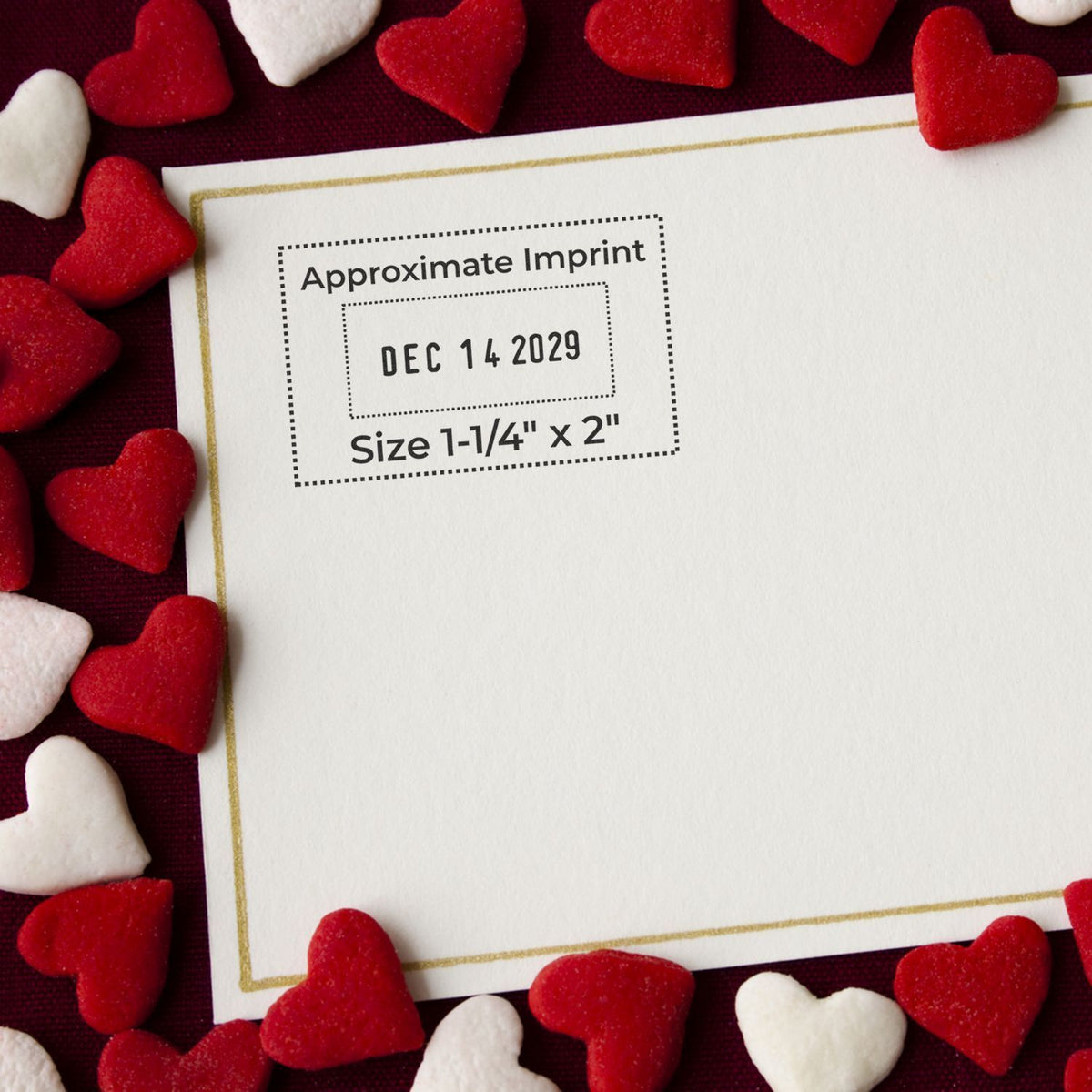 Valentines Day card mockup with red and white heart candies framing a blank custom stamp showing approximate imprint Dec 14 2029, size 1-1/4 x 2 inches.