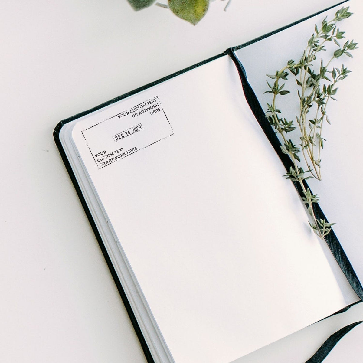 Minimalist open blank journal notebook with customizable cover text, botanical greenery, and elegant flat lay design on a white background.