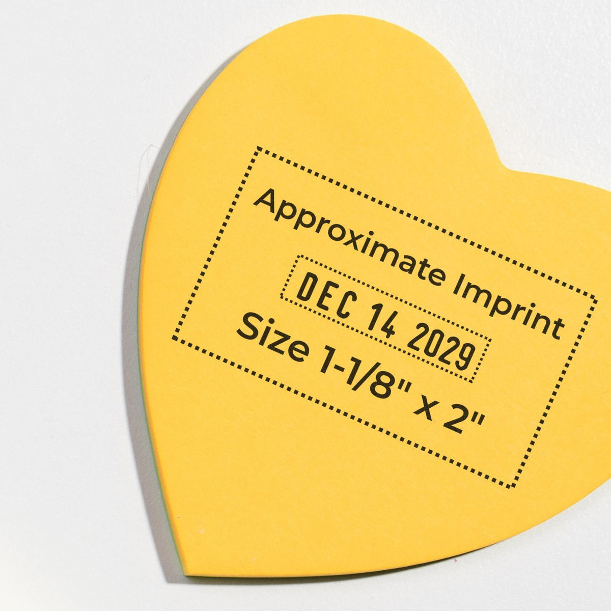 Yellow heart-shaped imprint sticker label reading Approximate Imprint, DEC 14, 2029, and Size 1-1/8 x 2 on a white background.