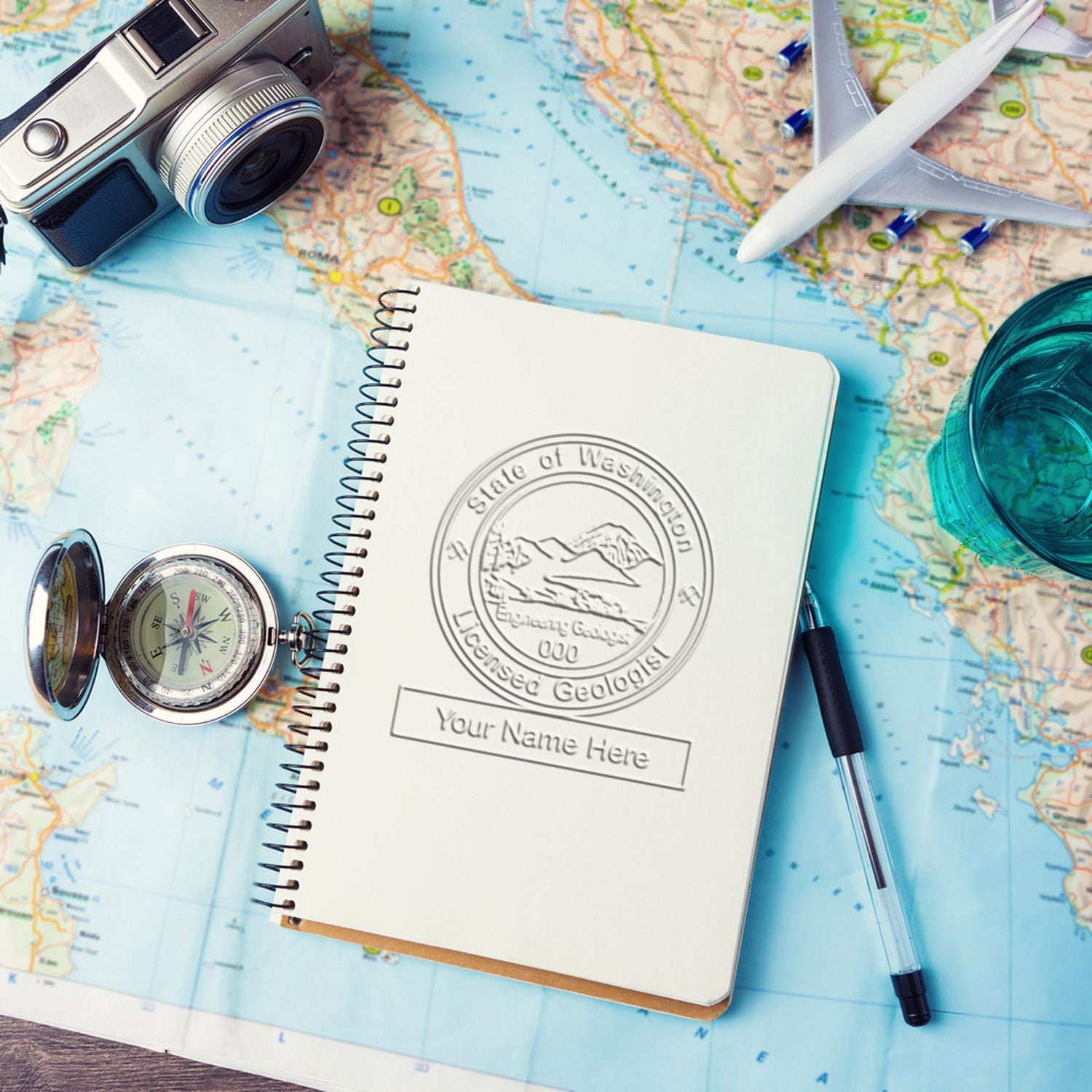 Travel planning flat lay with camera, airplane model, compass, notebook, and map background