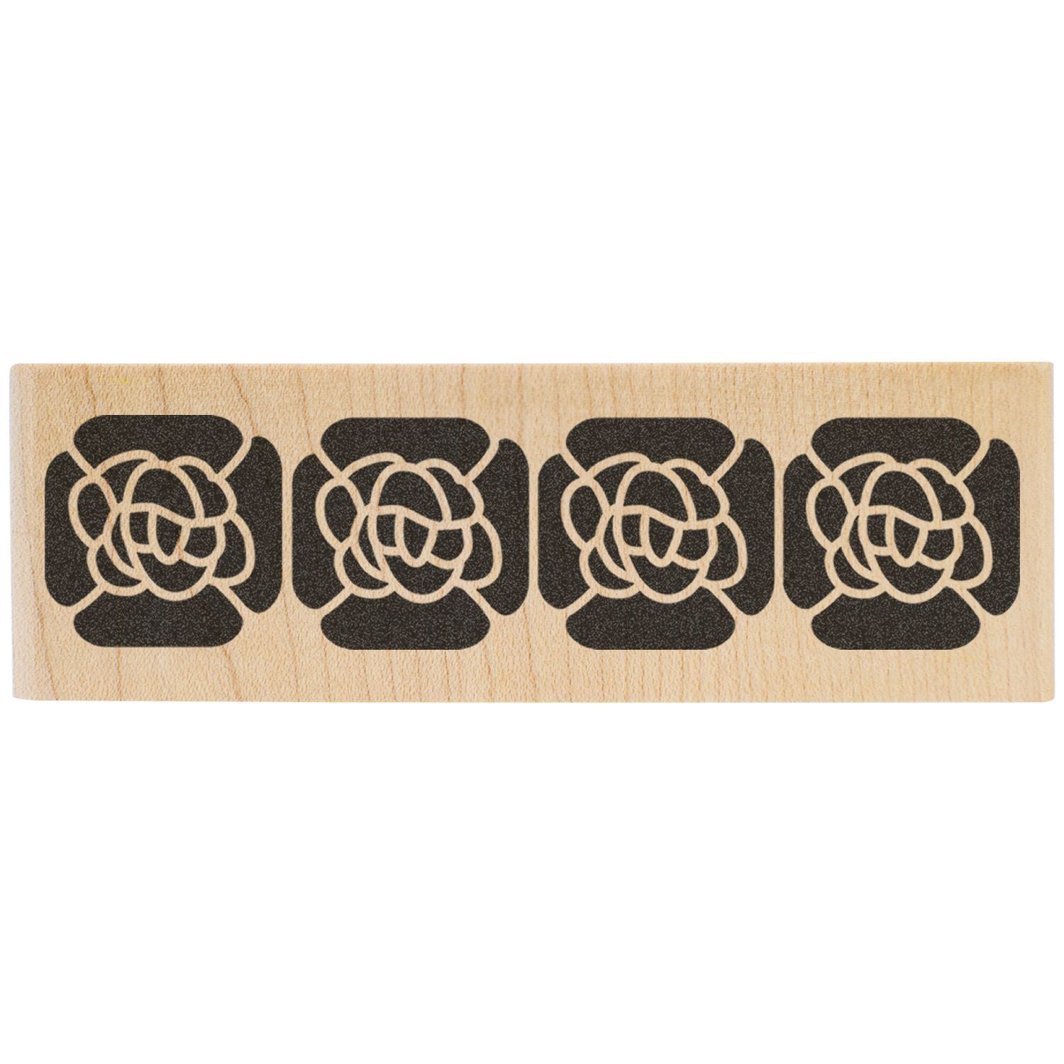 Wooden stamp block with four repeating black floral knot designs on a light natural wood surface.