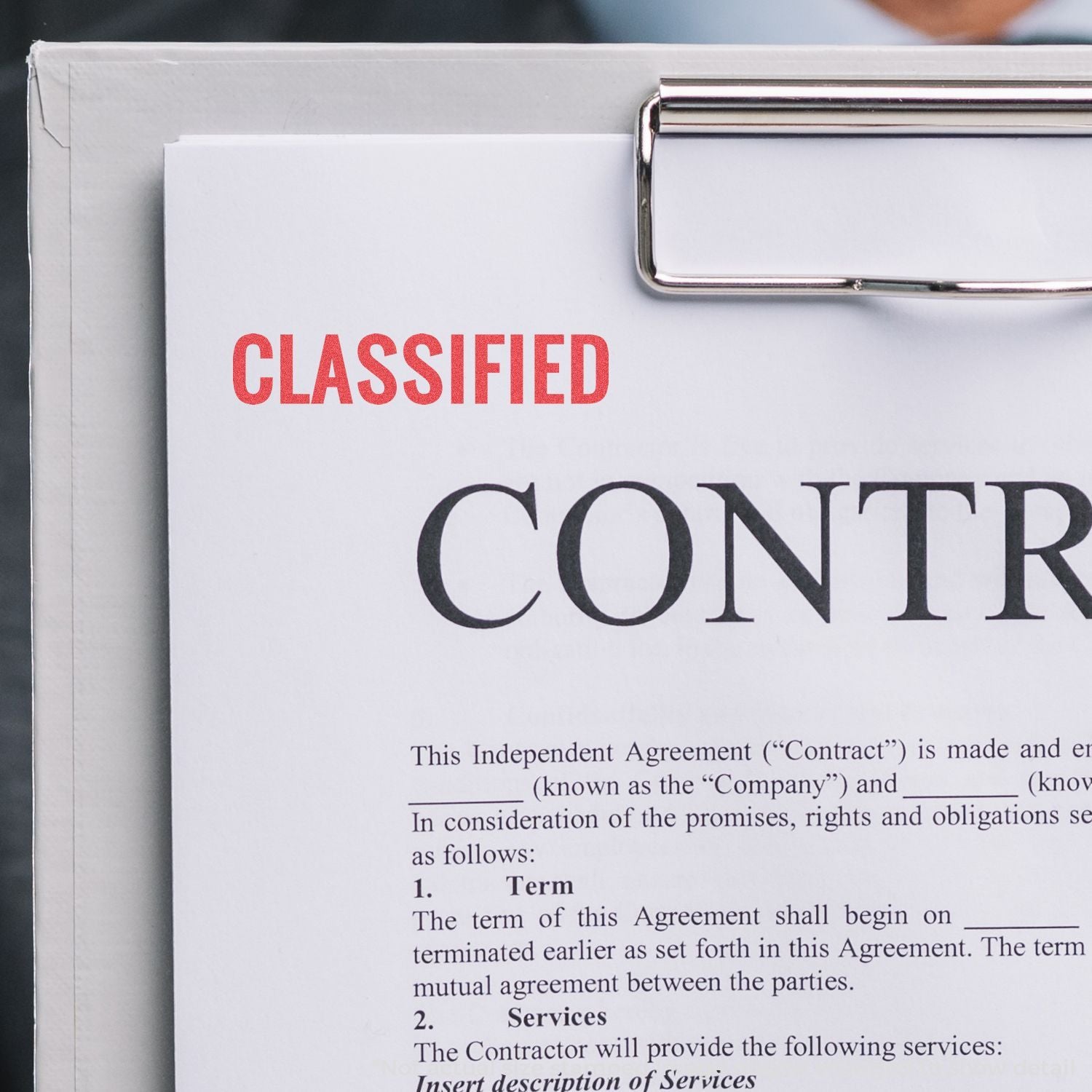 Classified contract document on clipboard showing CLASSIFIED label and independent agreement text for legal confidentiality context