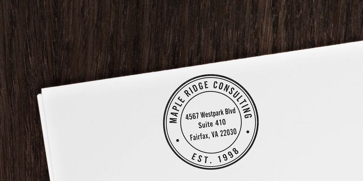 Maple Ridge Consulting branded stationery with circular logo and Fairfax, VA 22030 address on white paper over a dark wood background