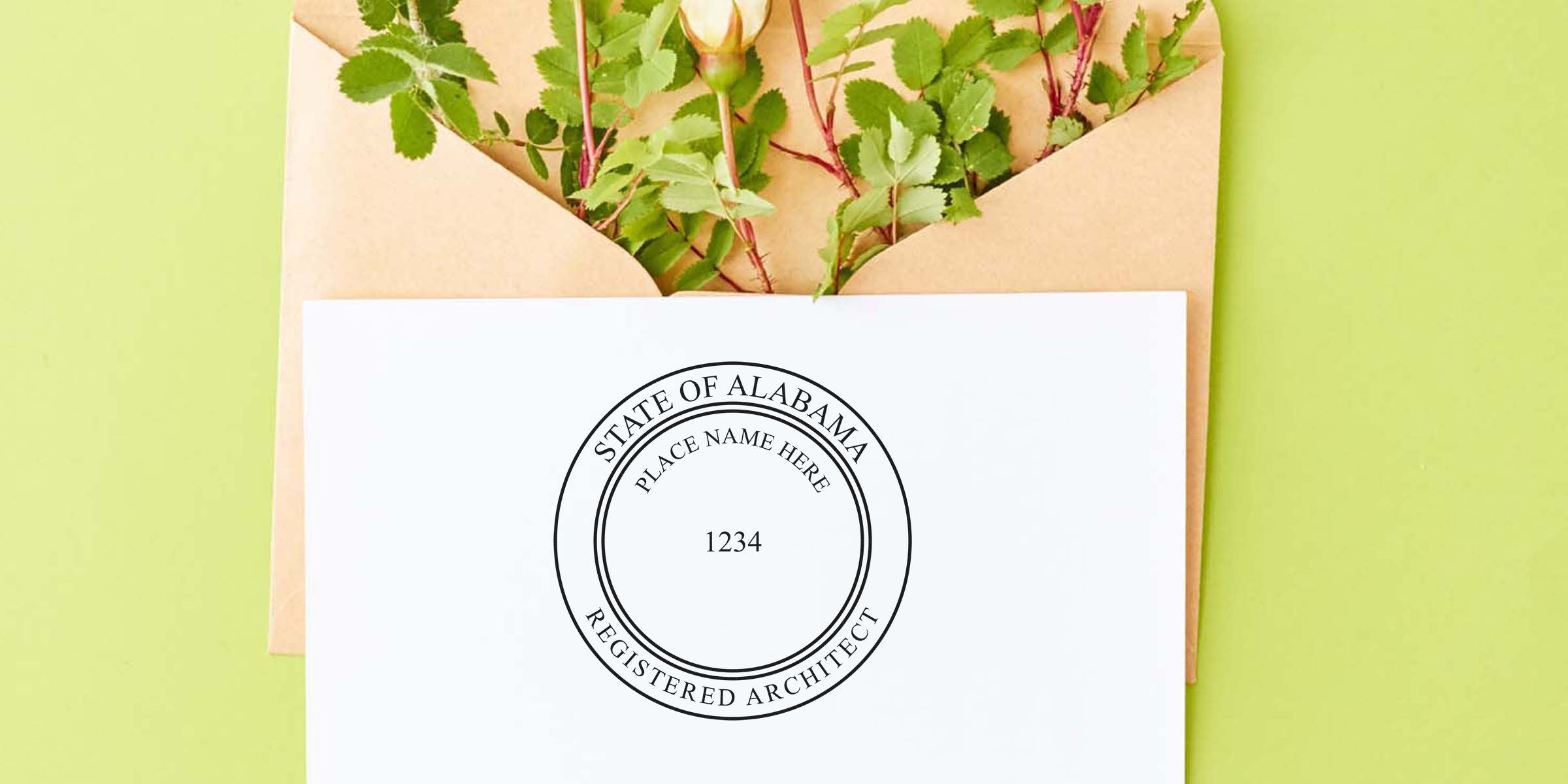 Alabama architect stamp on white paper with envelope and green leaves, showing the architect stamp and application process.