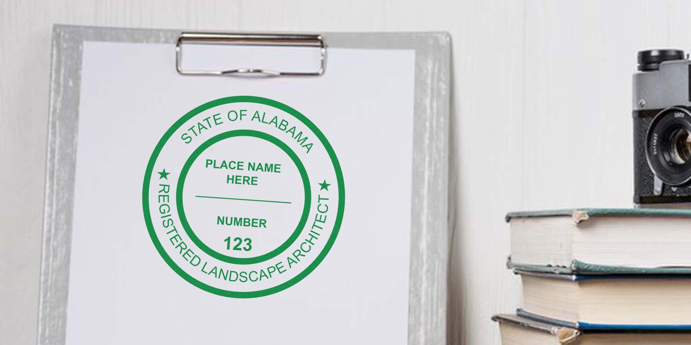 Alabama landscape architect’s clipboard with registered architect seal, vintage camera, and stacked books, symbolizing landscape architect licensing in Alabama.