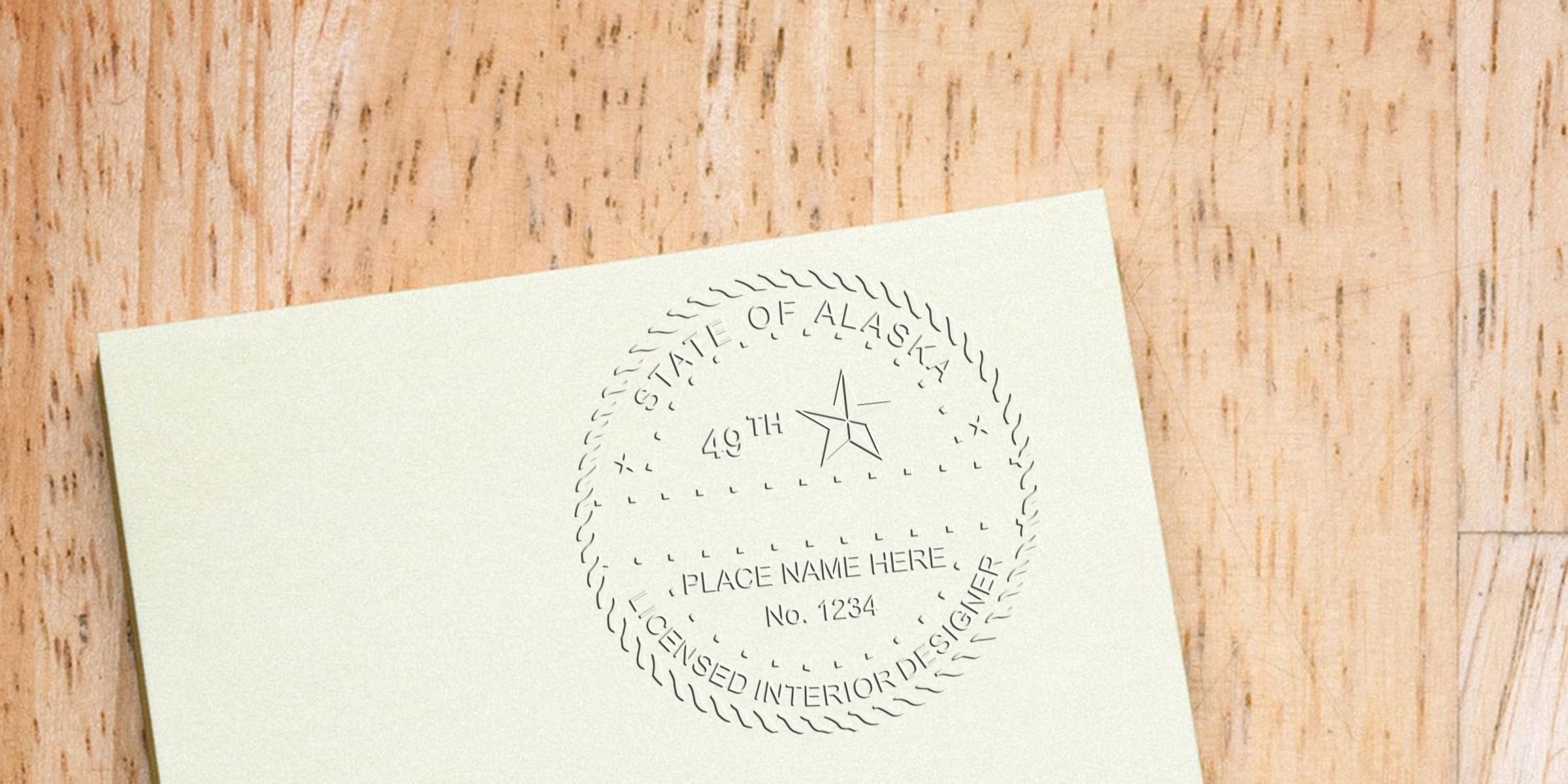 Embossed custom interior designer stamp of Alaska licensed seal on paper with wooden background, showcasing Alaska interior design tools.
