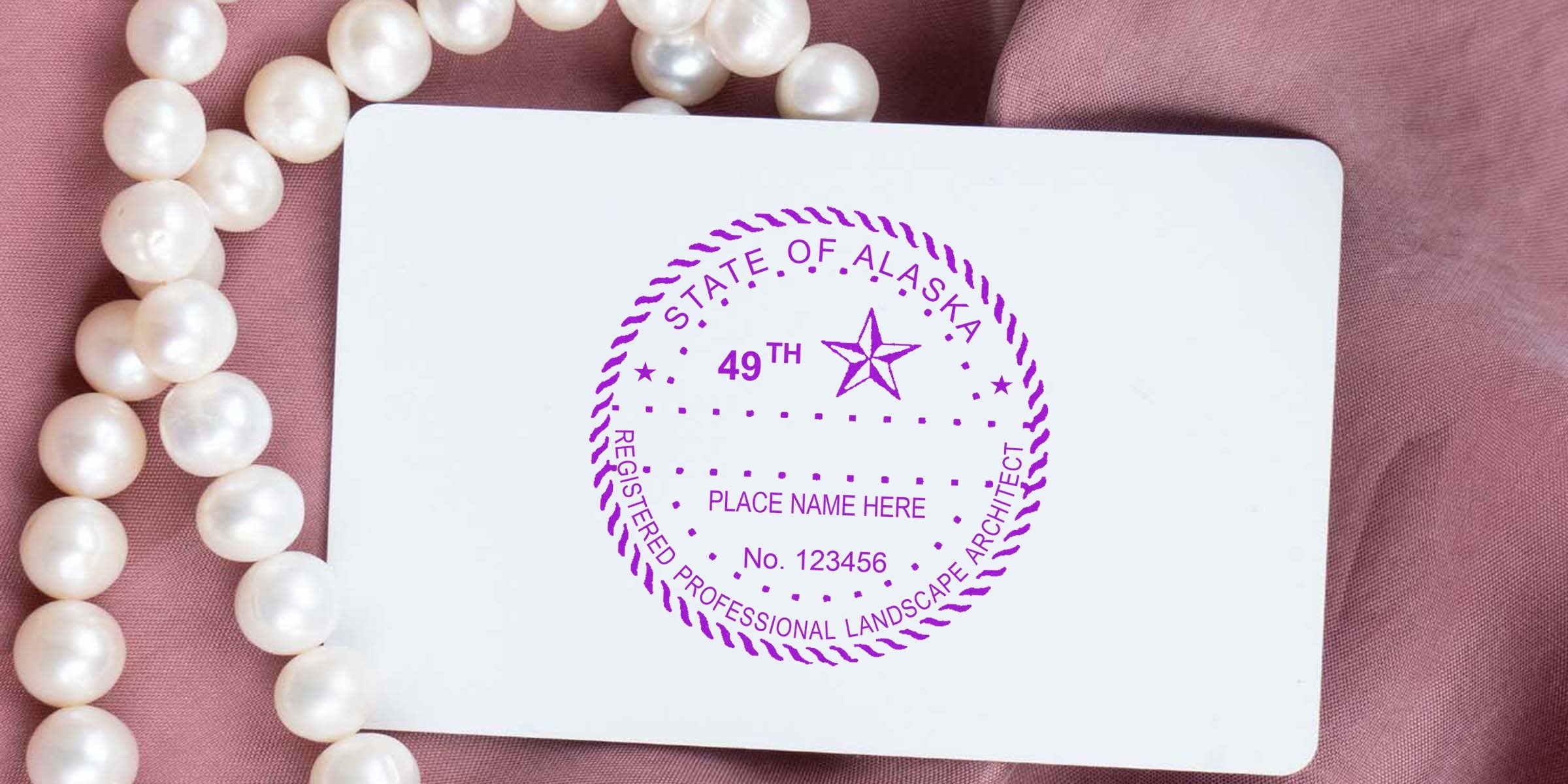 Alaska registered professional landscape architect seal on white card with pearl necklace and pink fabric background, showcasing Alaska and custom architect stamps.