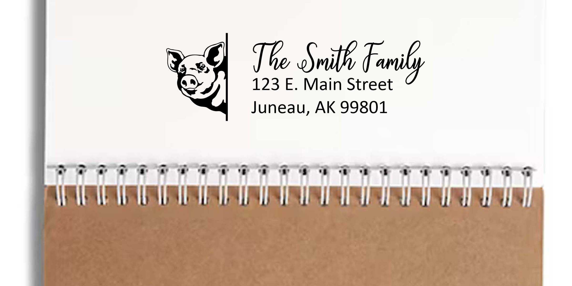 Personalized notebook cover with pig illustration and custom address label reading The Smith Family, 123 E. Main Street, Juneau, AK 99801