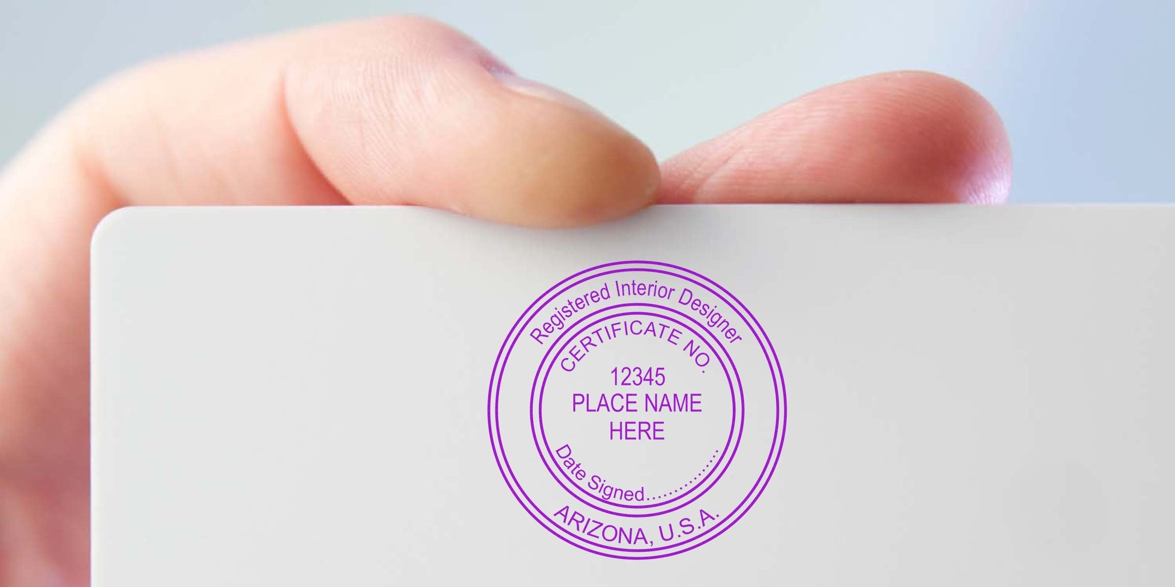 Hand holding a seal stamp on a registered Arizona interior designer certificate, showing certification number and location, highlighting the benefits of seal stamping.