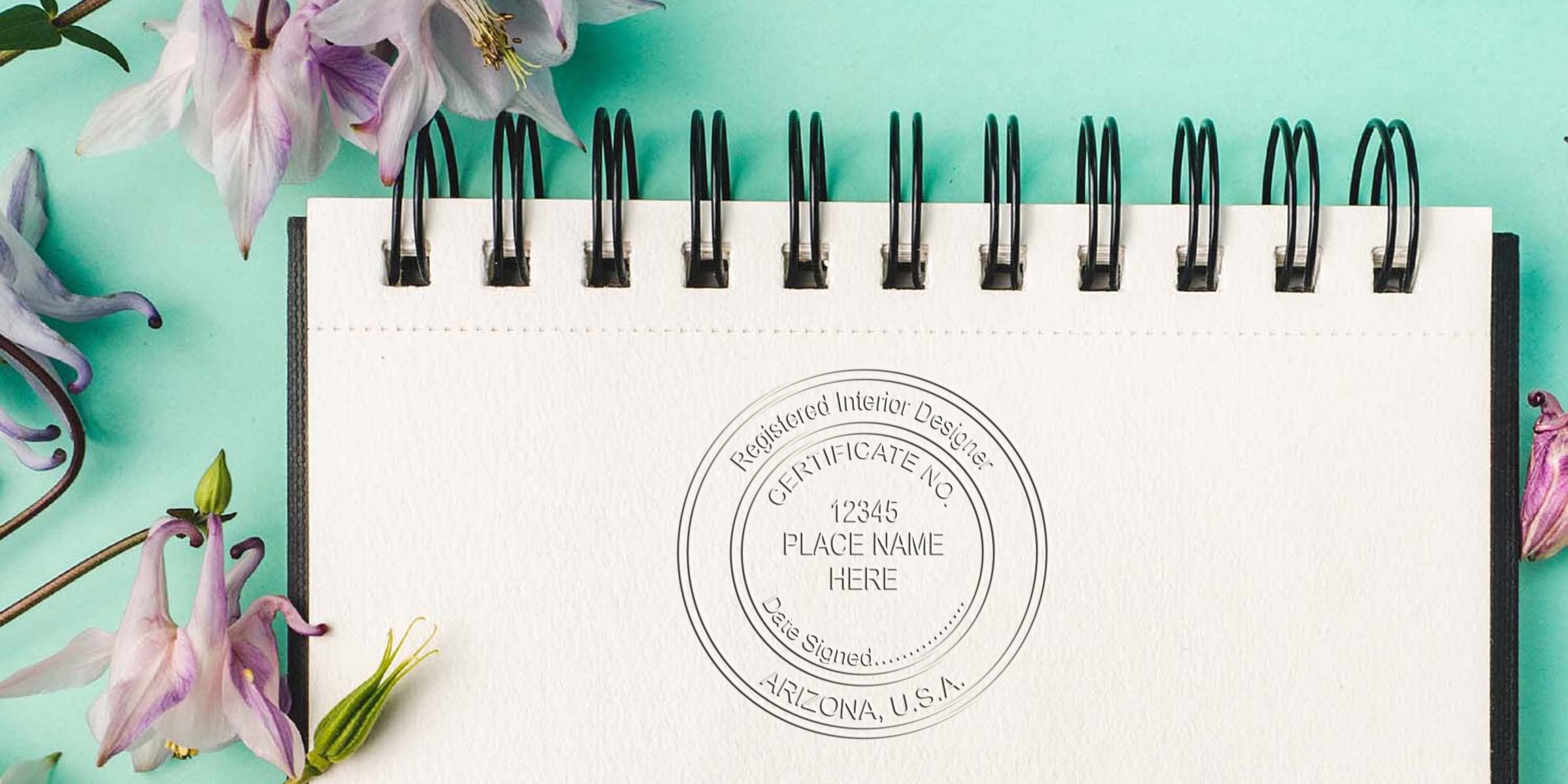 Registered interior designer certificate stamp on spiral notebook with flowers on turquoise background, symbolizing Arizona interior designer certification and online shopping list.