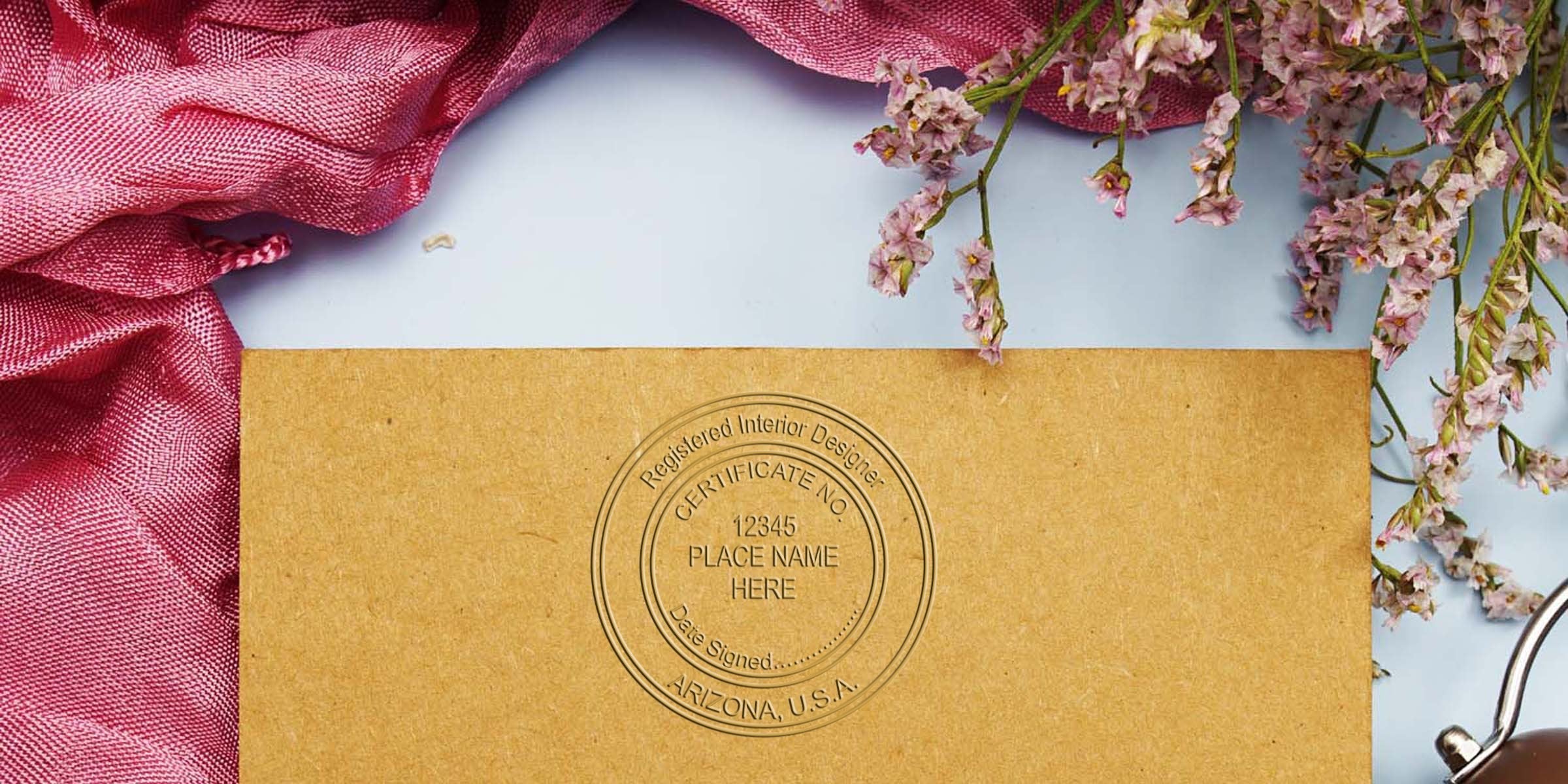Interior designer certificate on brown paper with Arizona stamp, pink fabric, and flowers, highlighting Arizona interior design certification.