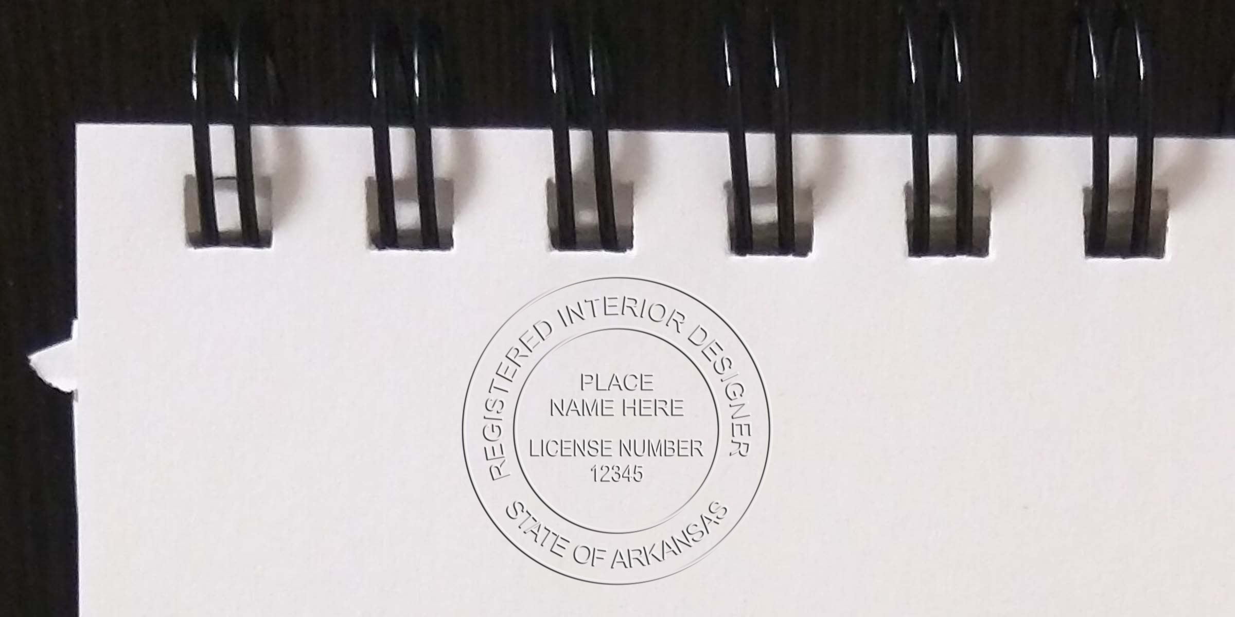 Arkansas interior designer stamp on white spiral notebook, official license seal, certified interior designer stamp, interior designer stamp application Arkansas.