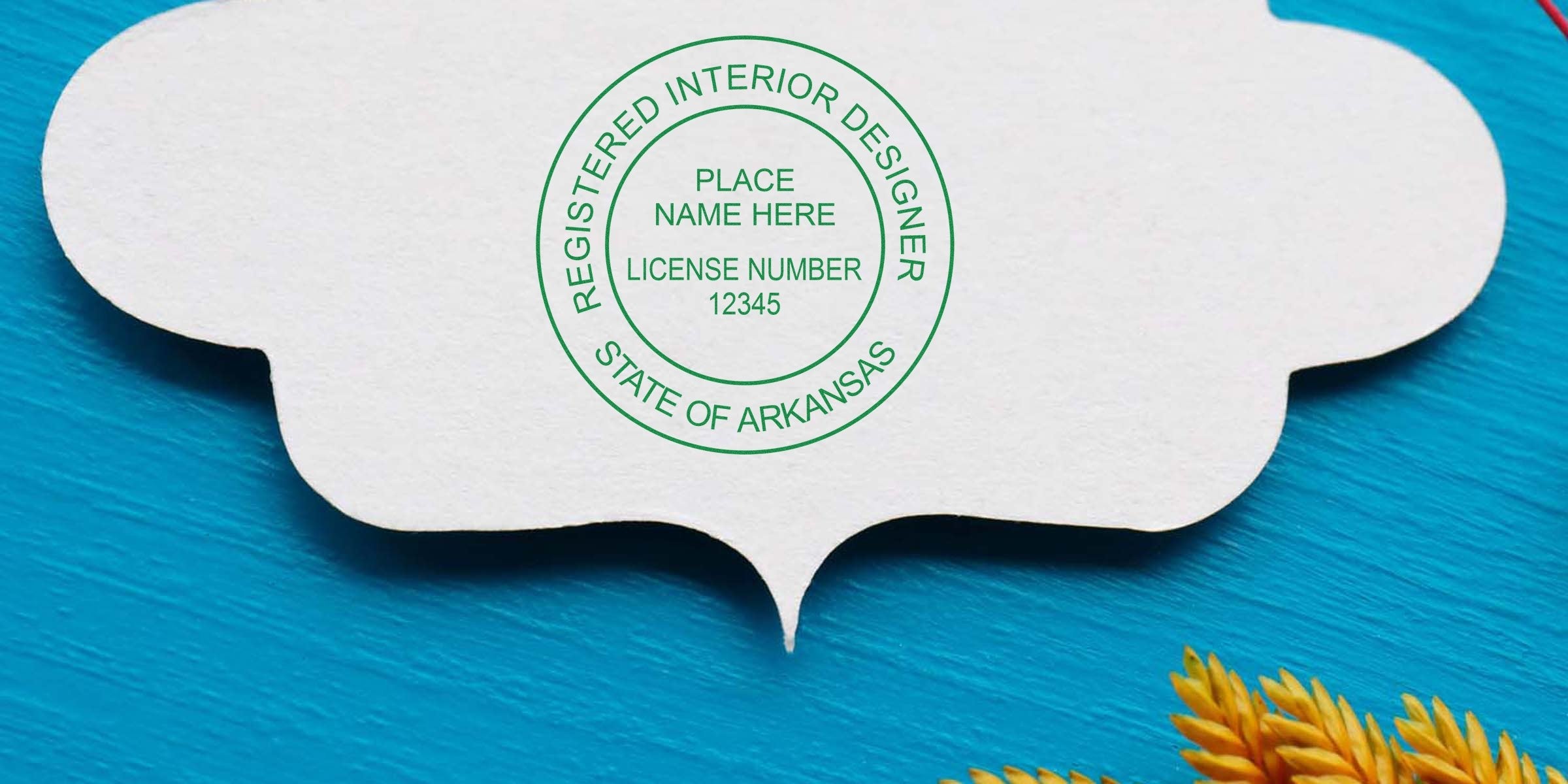 Arkansas interior designer stamp on white paper with yellow wheat on blue wood, showing license number 12345, representing Arkansas interior design licensing.