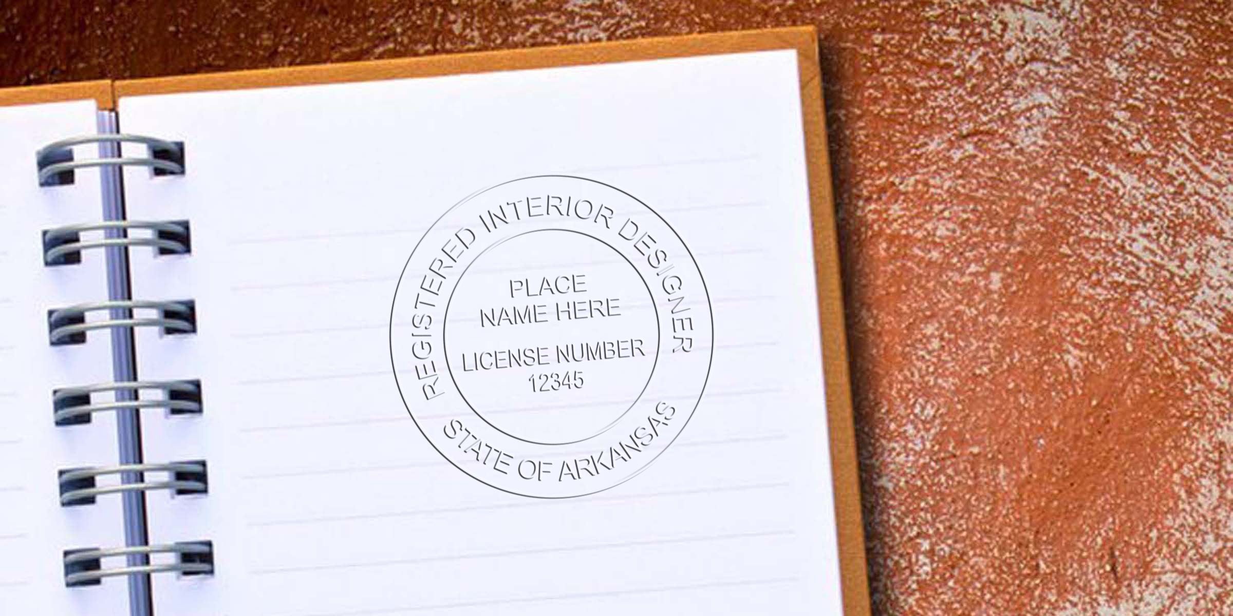 Arkansas interior designer license stamp on open spiral notebook, emphasizing Arkansas interior design licensing requirements.