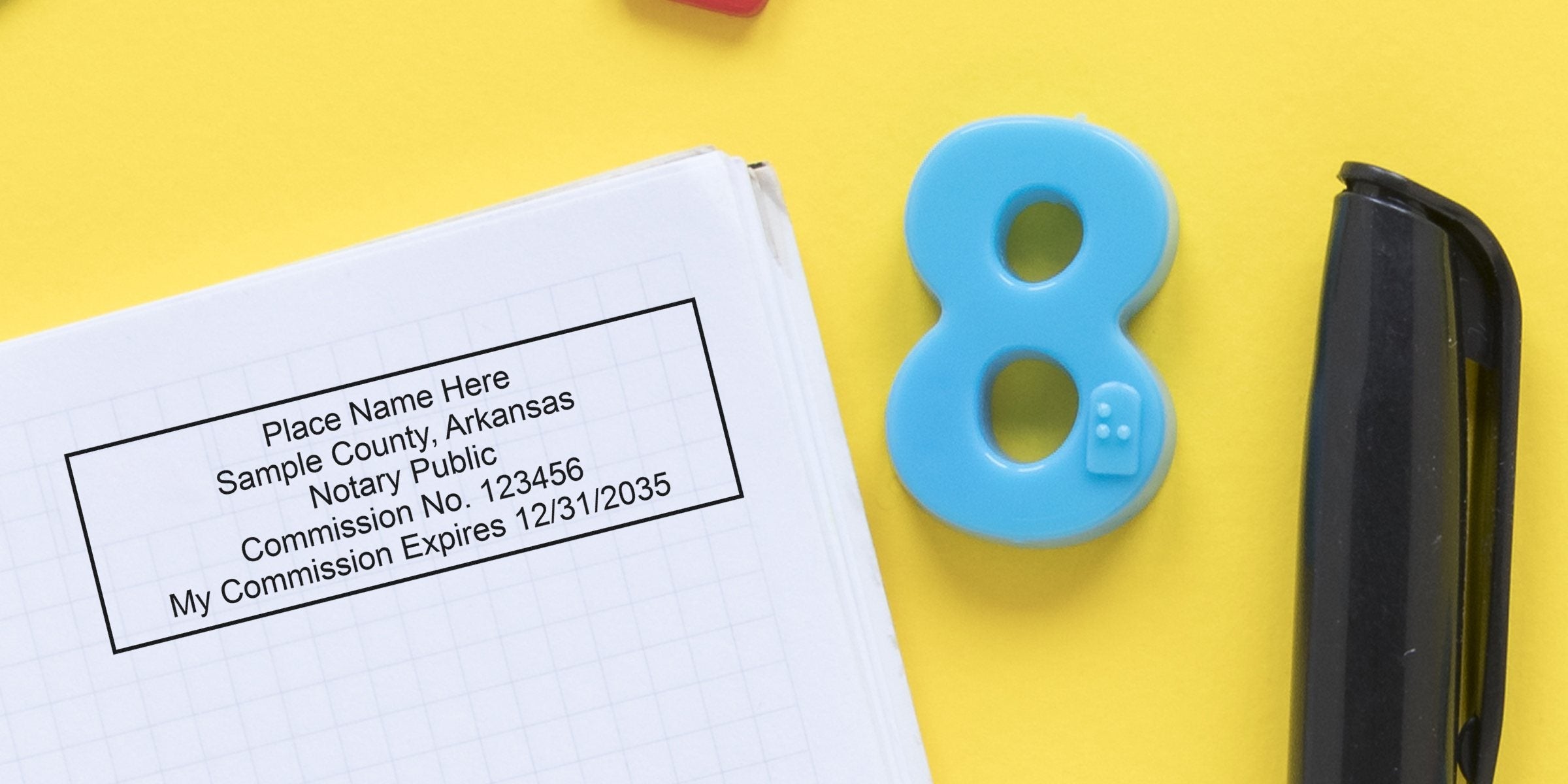 Notary public stamp with commission info, blue number 8, black stapler on yellow background, showcasing Arkansas notary supplies and essentials.