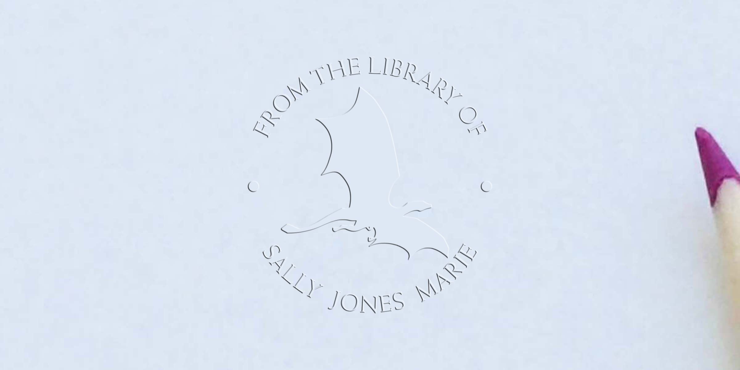 Embossed “From the Library of Sally Jones Marie” bookplate design on white paper with a pencil tip visible on the right.