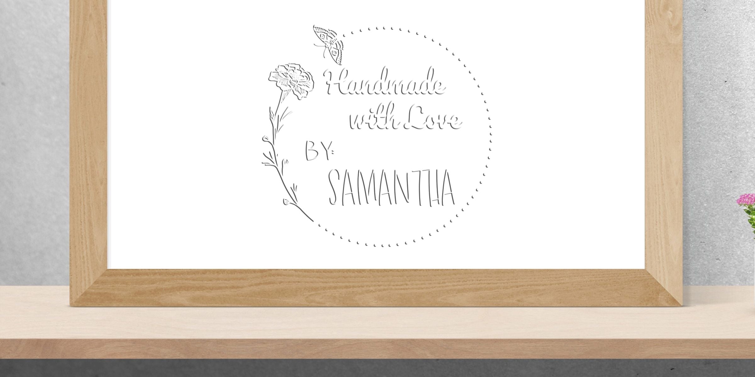 Framed minimalist wall art with floral butterfly design and handwritten text reading “Handmade with Love by Samantha” on a white background