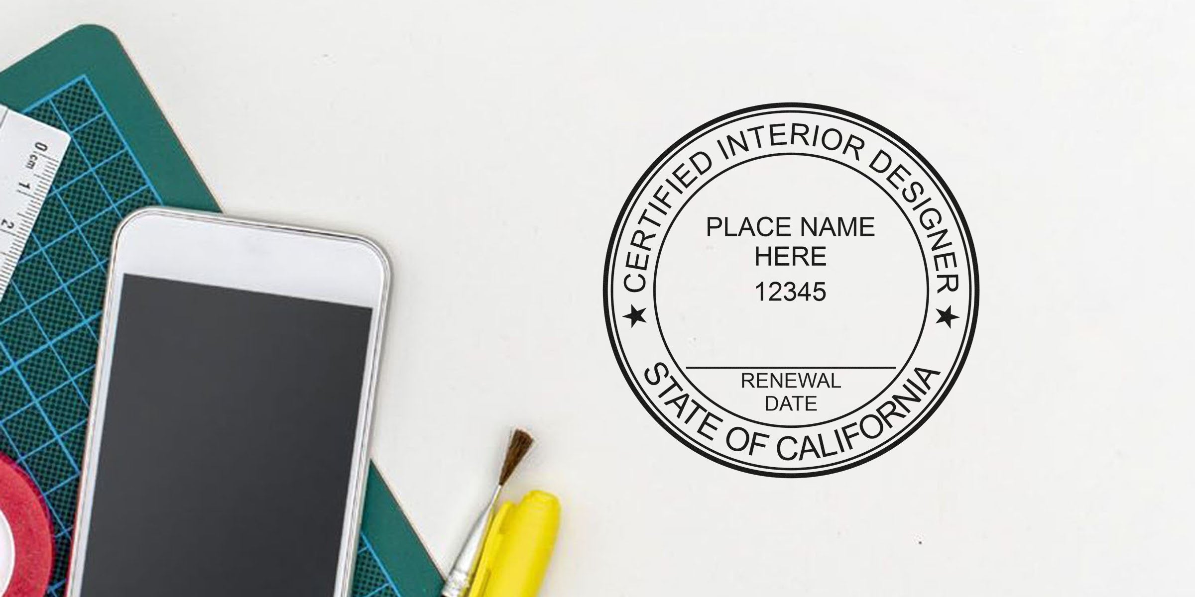 Certified California interior design stamp with smartphone and key seal design tools on white desk.
