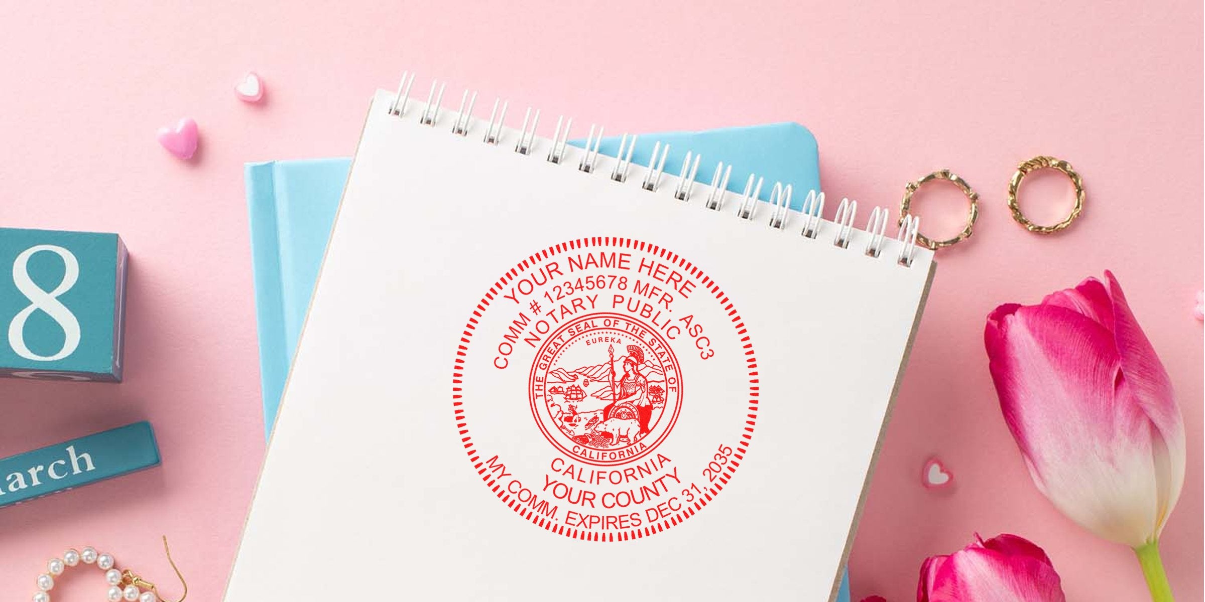 California notary seal stamp on a notebook with pink tulips and gold rings on a pink background, highlighting key notary stamp tips.