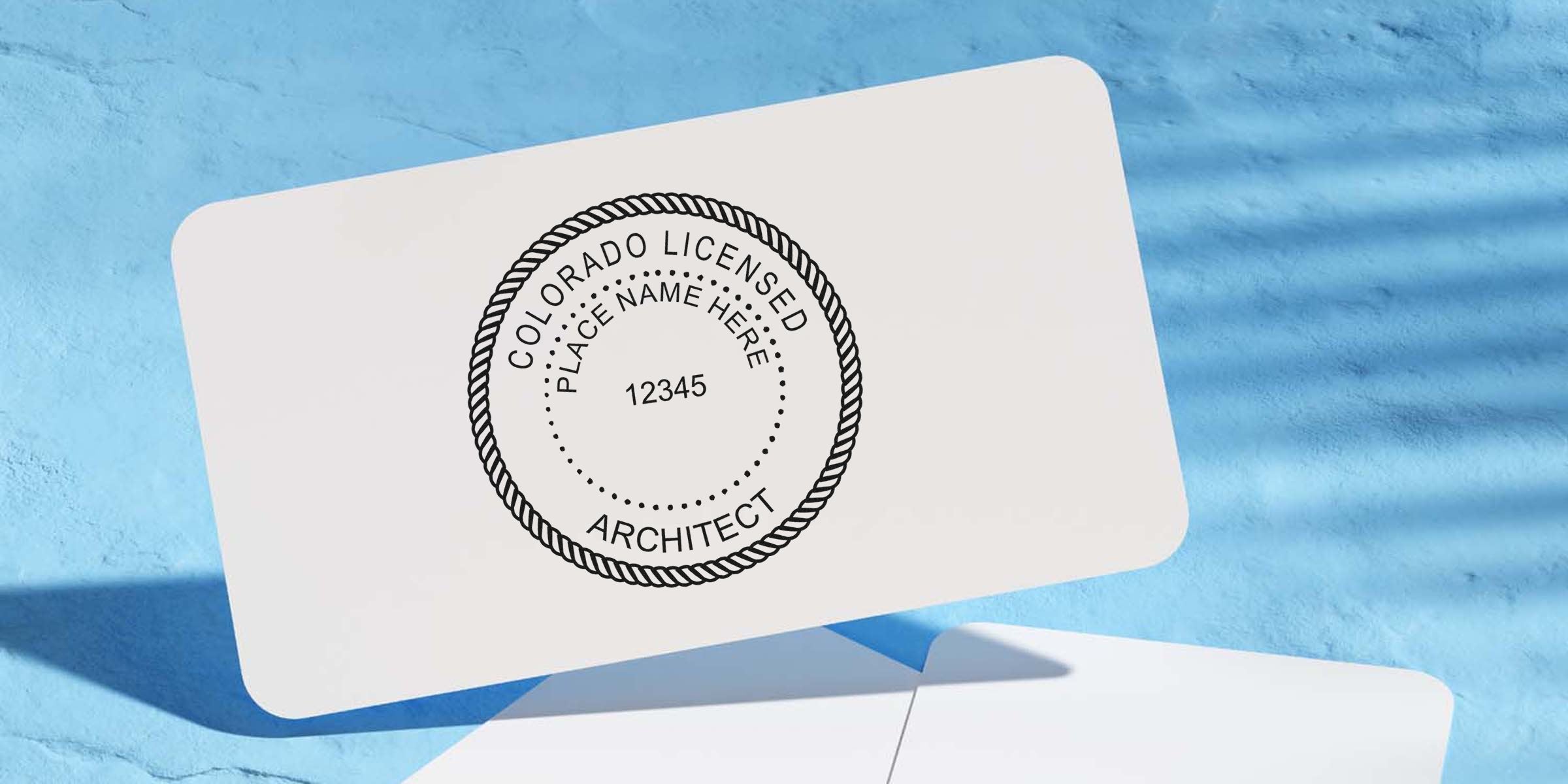 Colorado architect seal stamped on white card against blue textured background, displaying seal authentication.