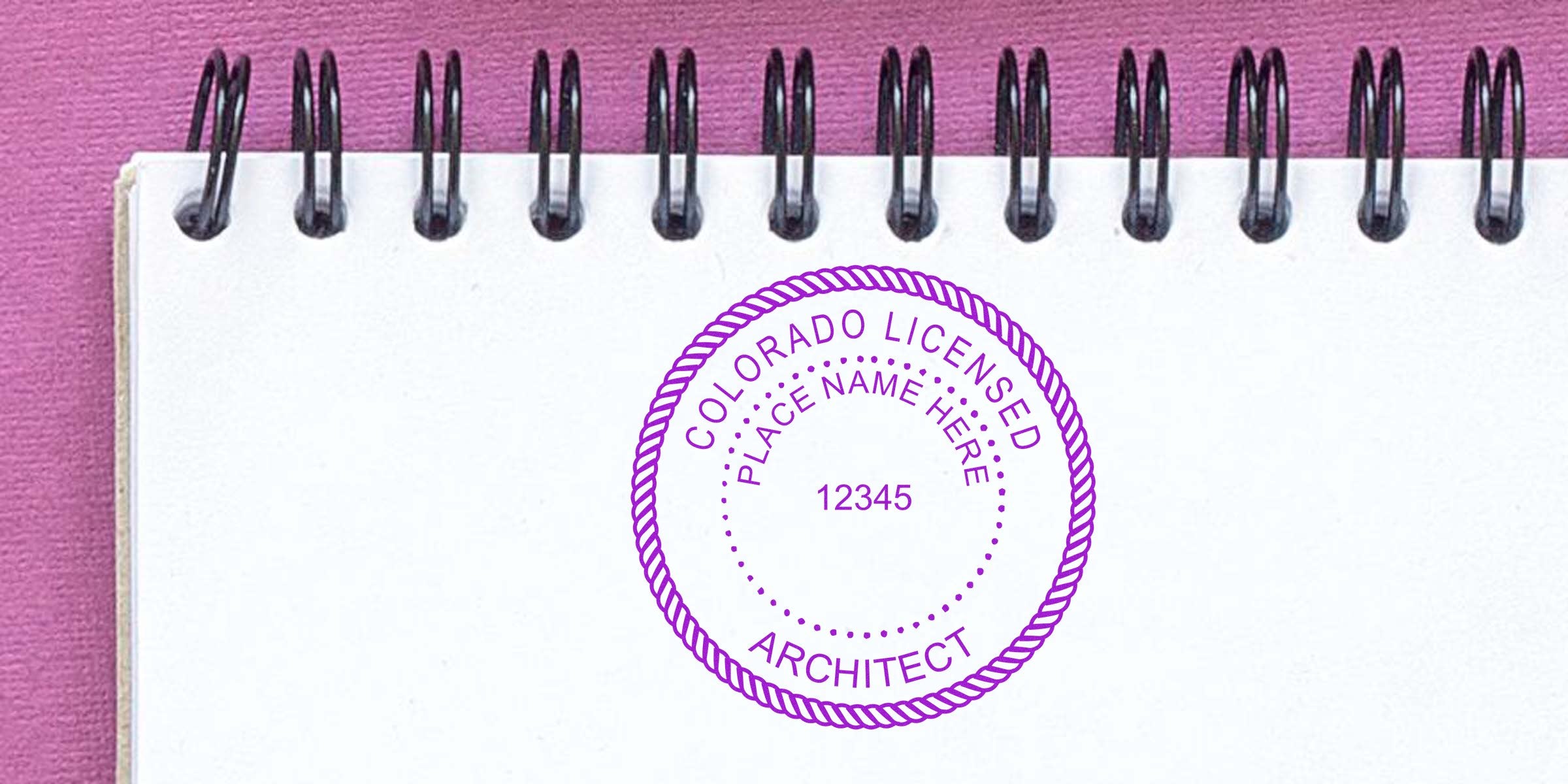 Colorado architect stamp on white notebook against purple background, emphasizing selecting an architect stamp in Colorado.