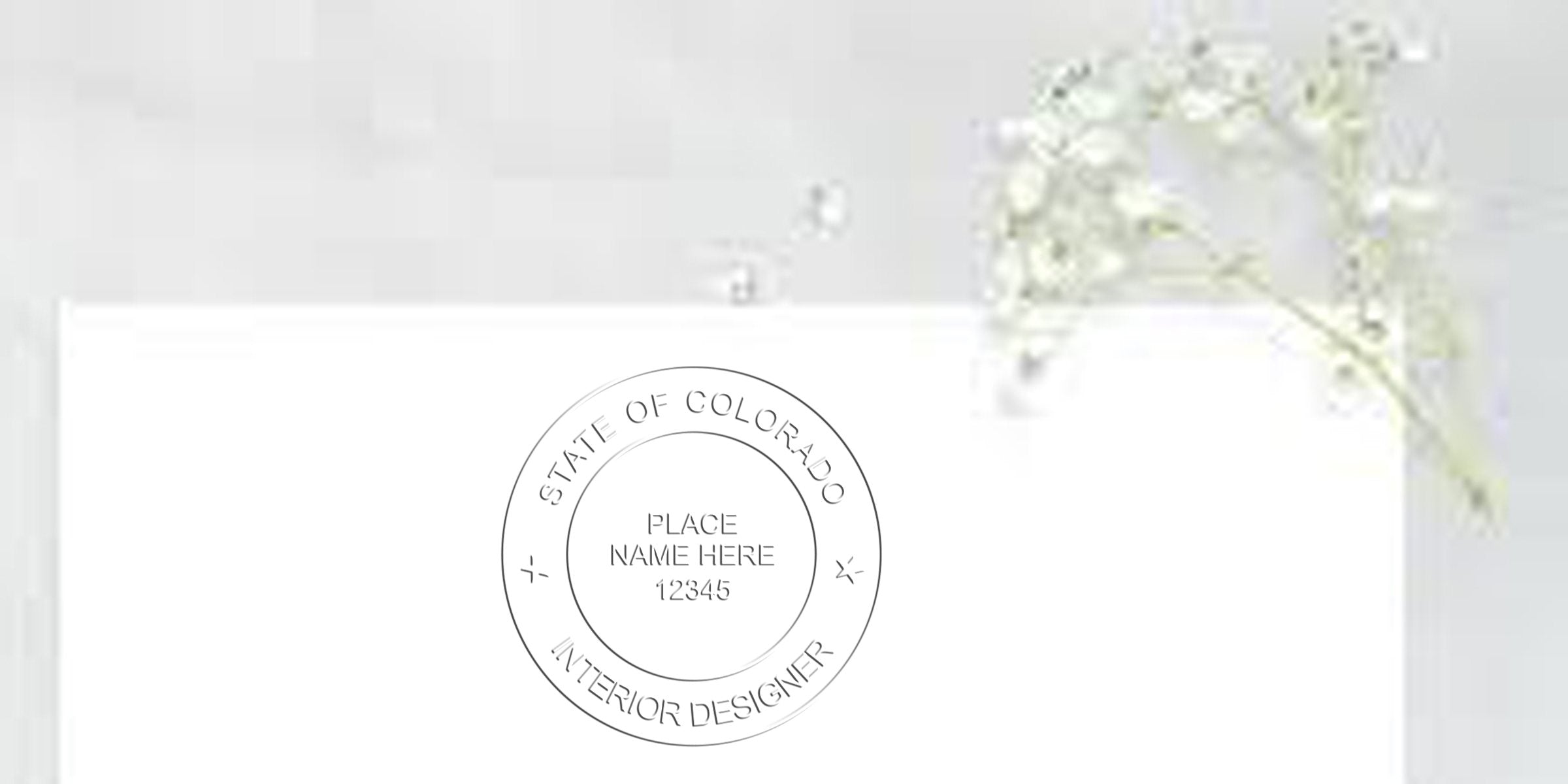 Colorado interior designer stamp on white paper with floral design, highlighting Colorado interior designer stamp cost and fees.