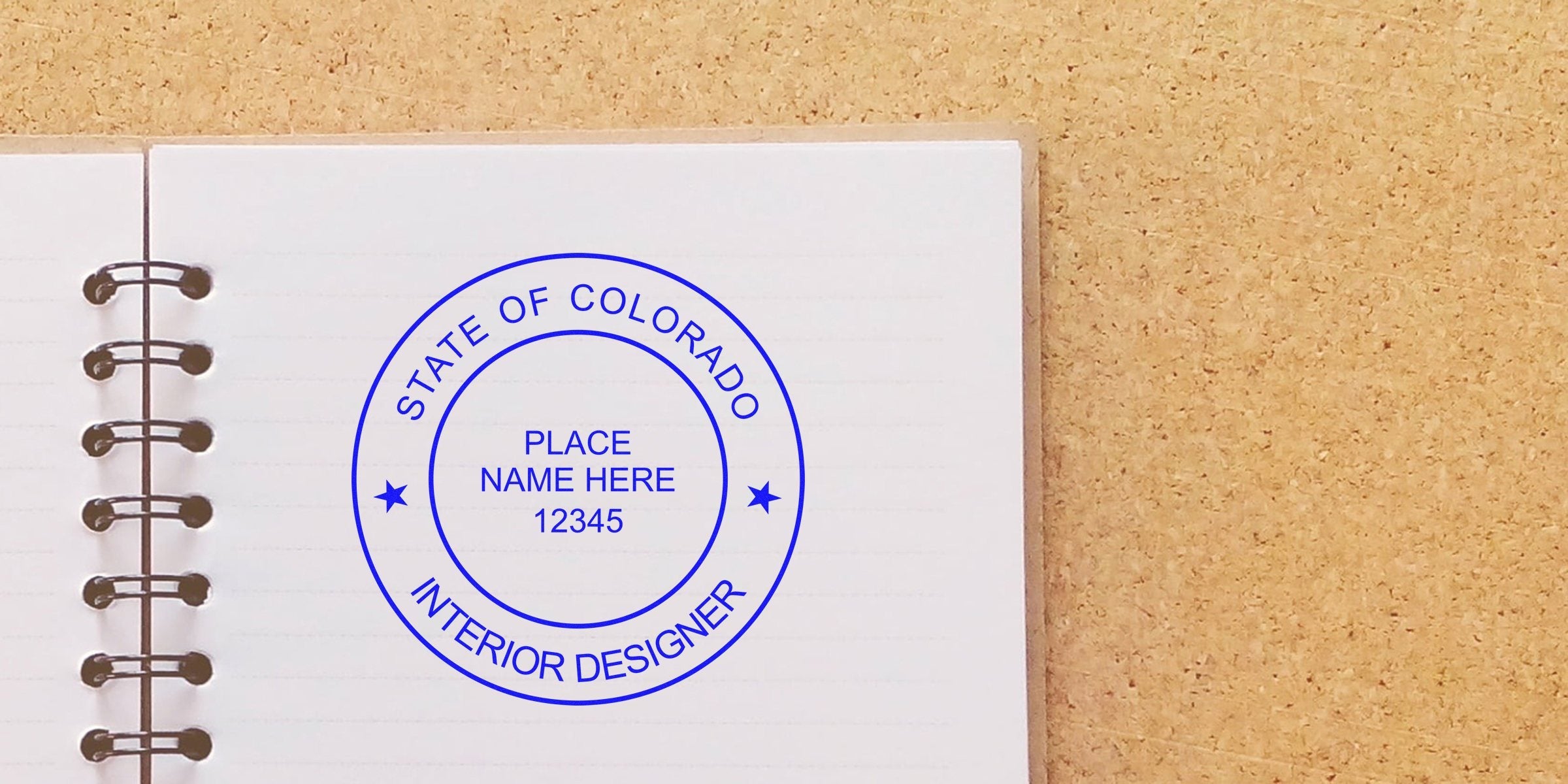 Colorado interior designer seal stamped on a notebook against a corkboard, showcasing interior design details.