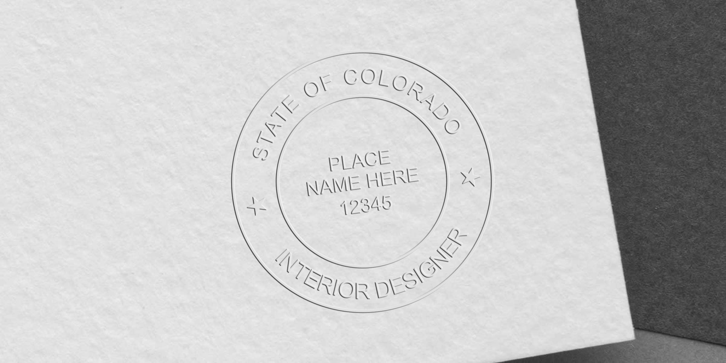 Embossed Colorado interior designer seal on textured white paper with customizable name and number, showcasing authentication and seal verification steps.