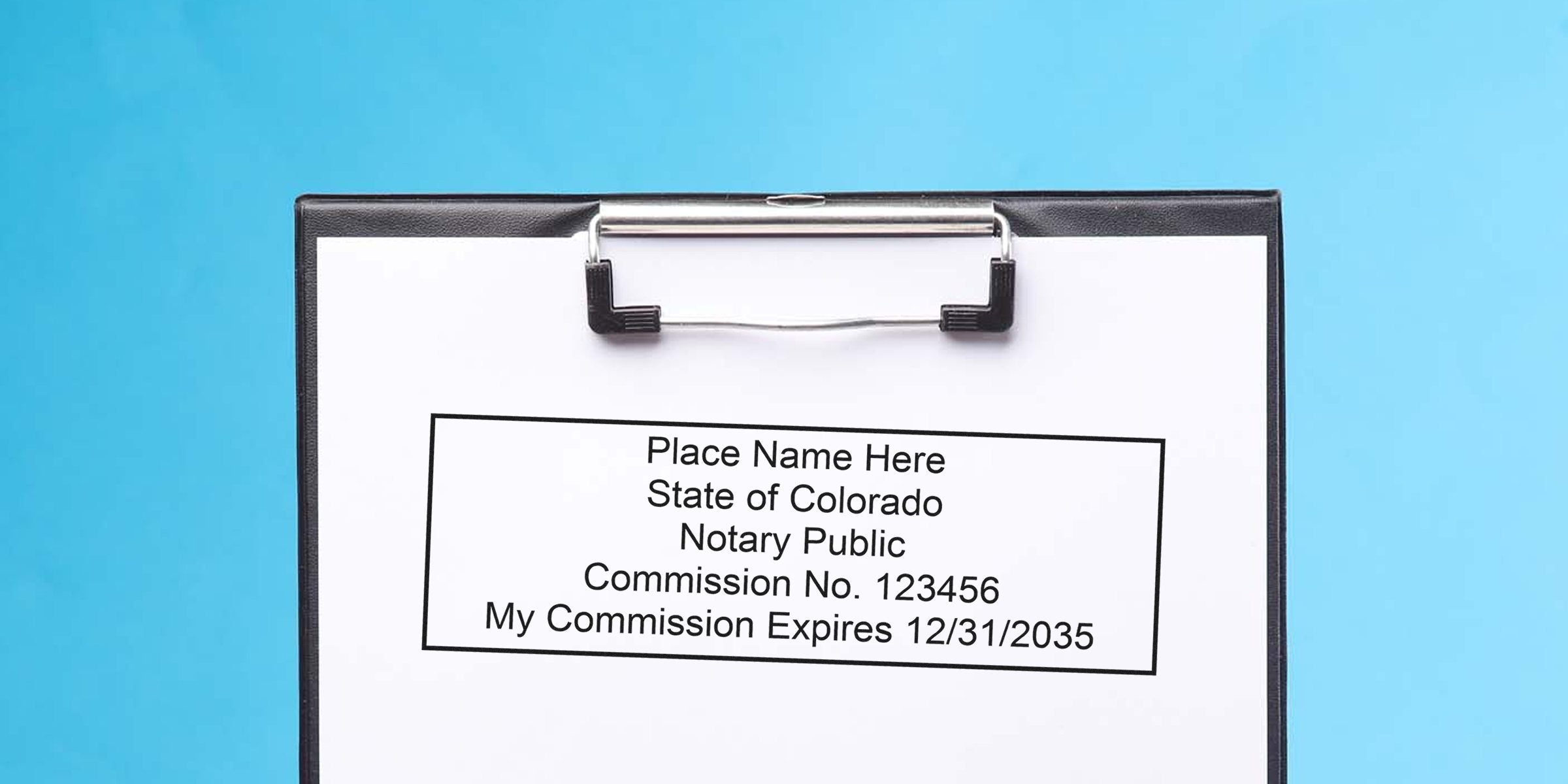Colorado notary public commission certificate on clipboard with blue background and Colorado notary stamp; purchase notary supplies in Colorado.