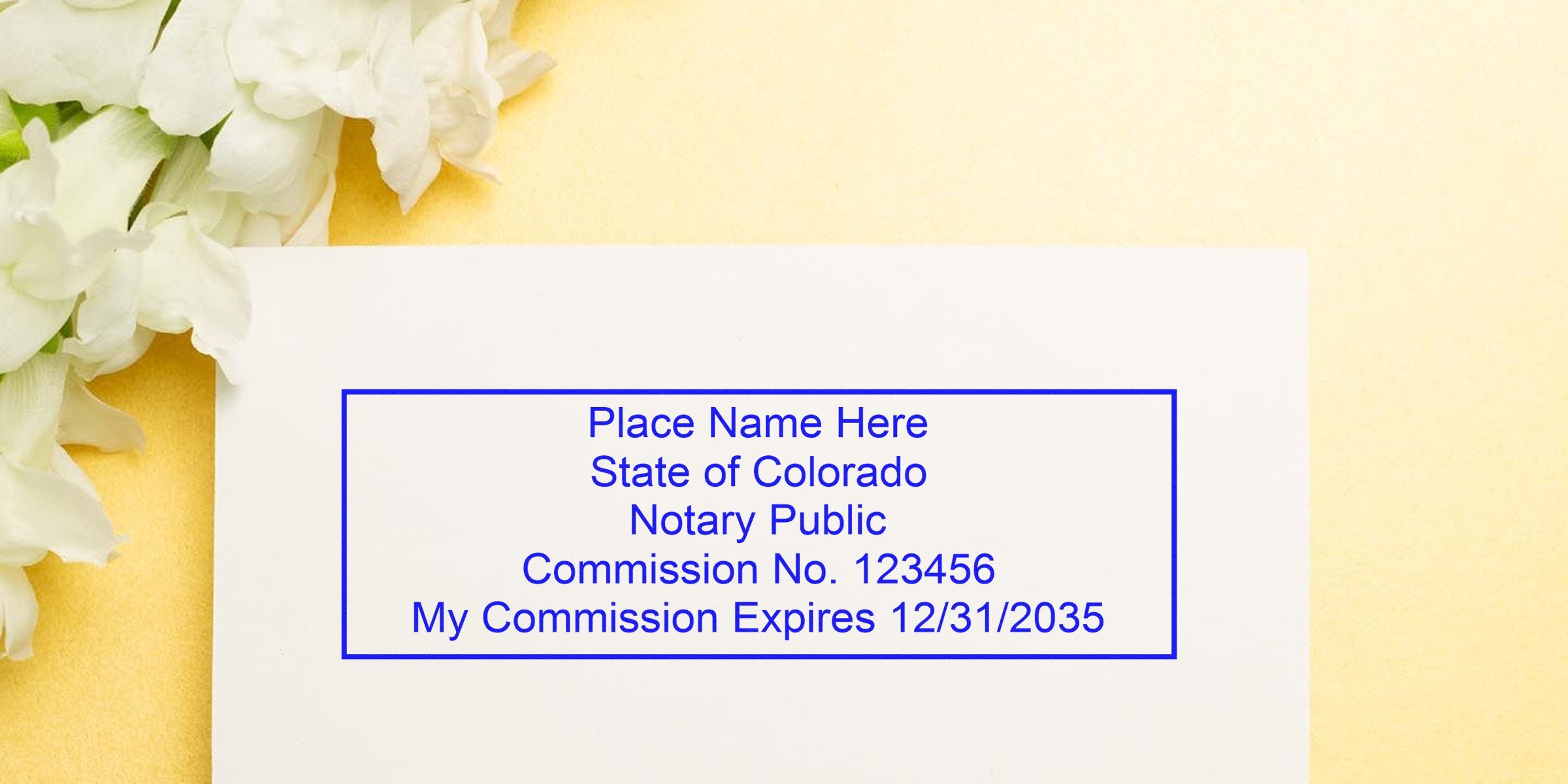 Colorado notary seal stamp with expiration date on white card, surrounded by flowers, meeting all Colorado notary seal requirements.