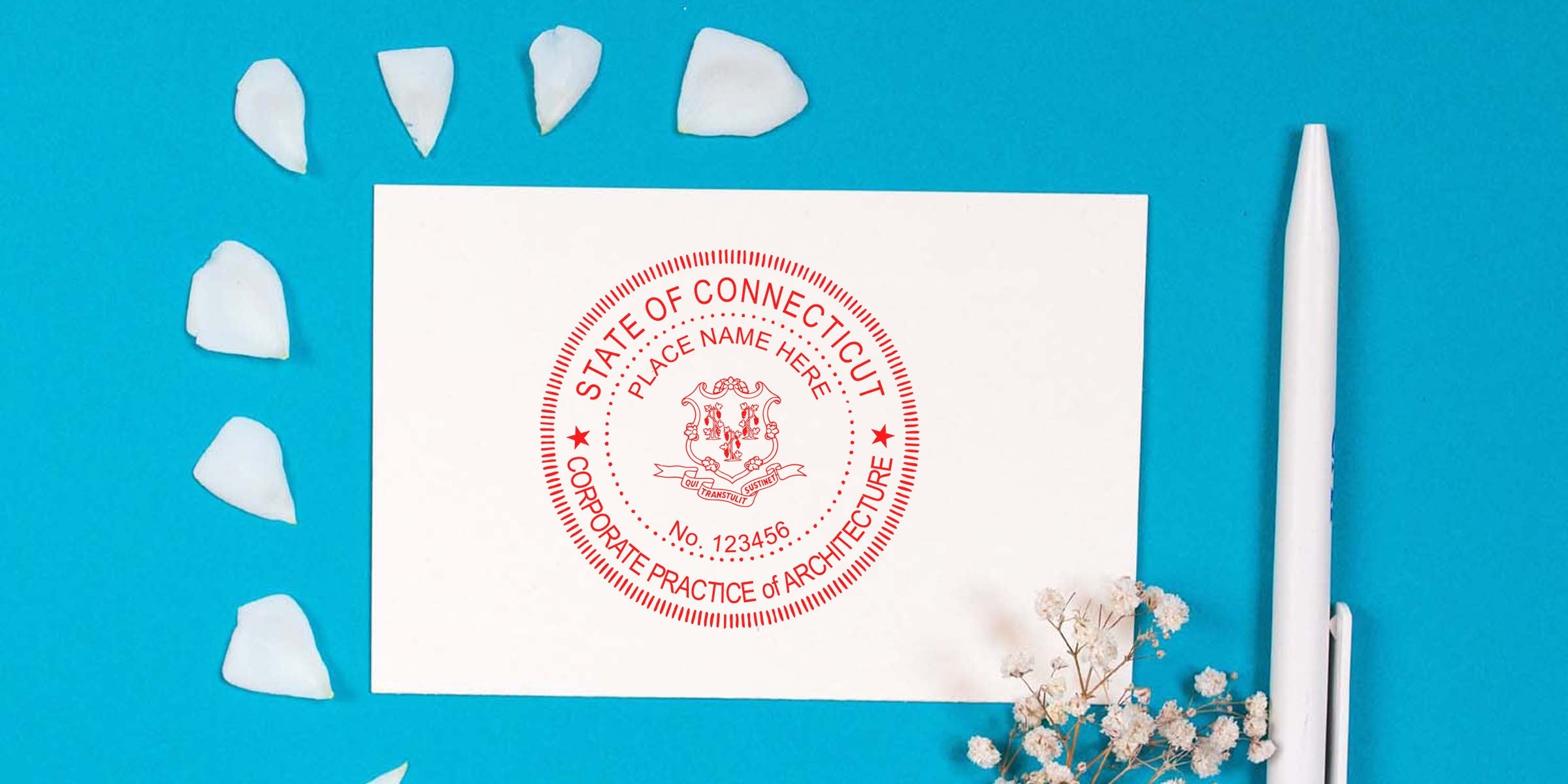 Connecticut architect seal stamp on white card with pen and flower petals on blue background, emphasizing Connecticut architect seal rules.