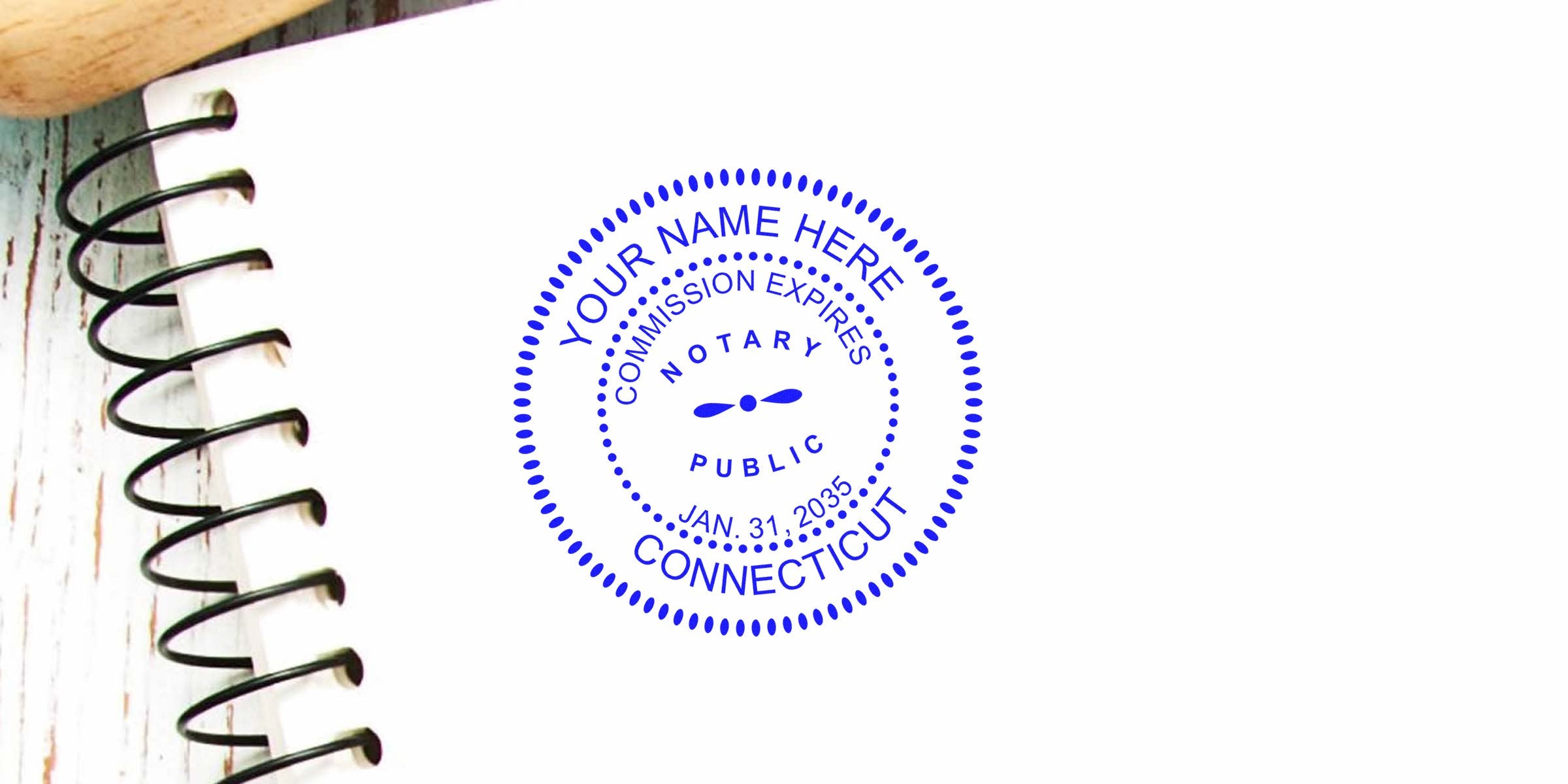 Connecticut notary public stamp on spiral notebook with wooden background, part of essential Connecticut notary kit.