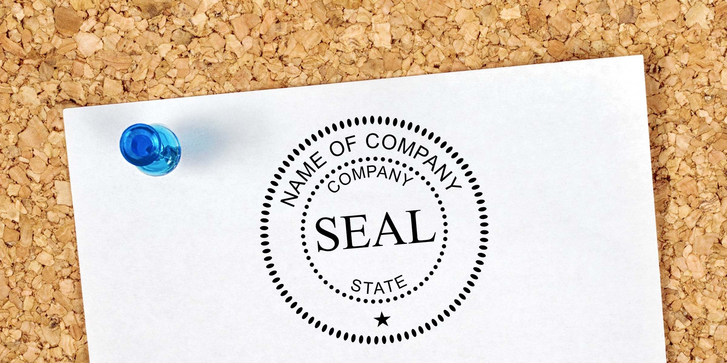 Blank company seal stamp on white paper pinned to a corkboard with a blue pushpin