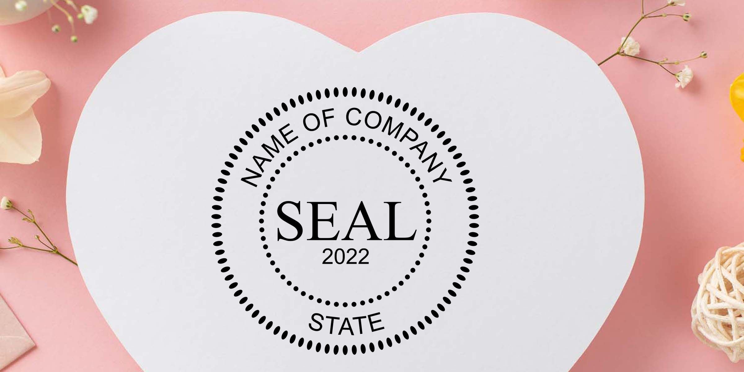 Heart-shaped white card with custom company seal logo reading “NAME OF COMPANY SEAL 2022 STATE” on a pink floral background.