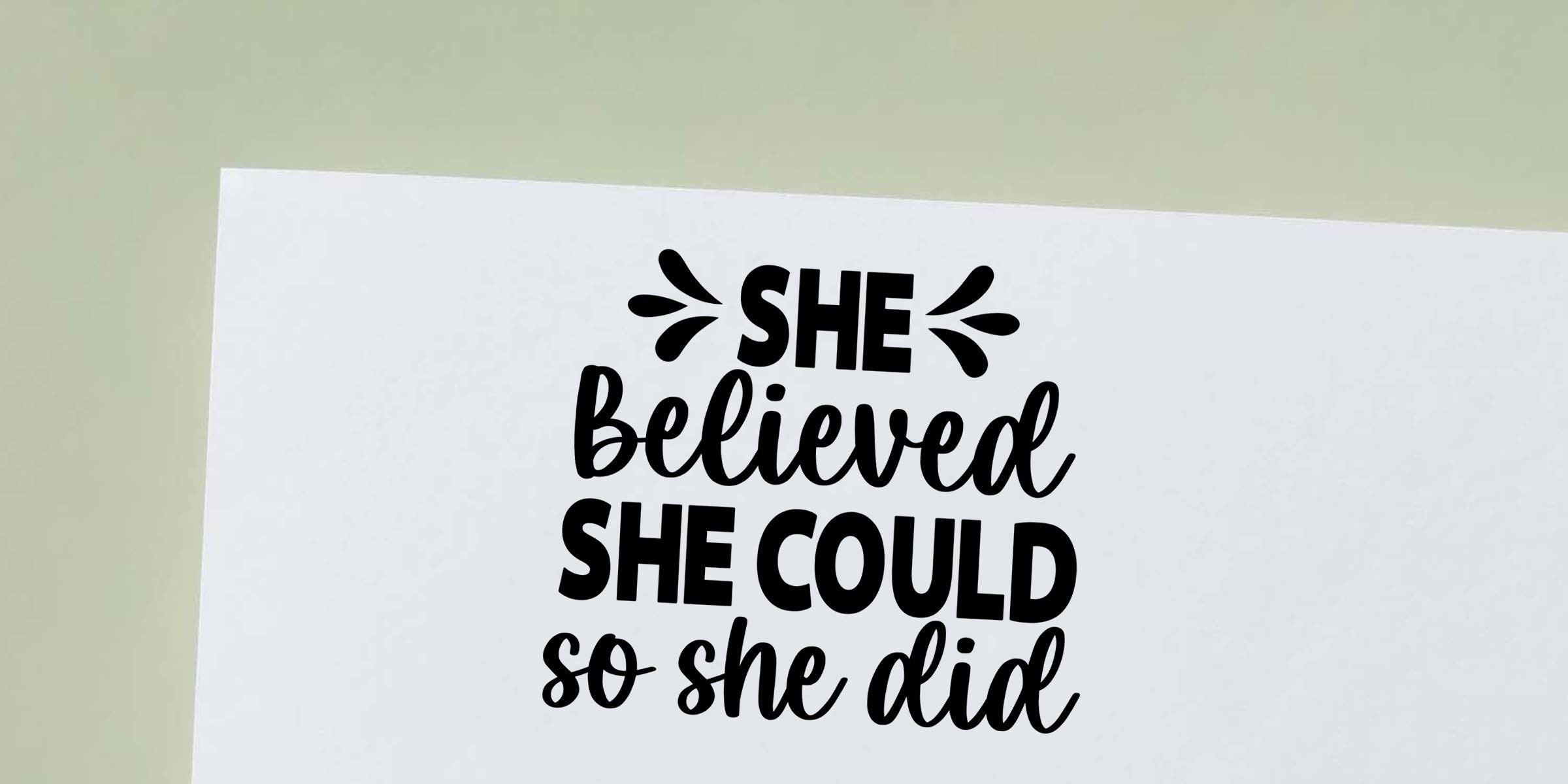 “She believed she could so she did” motivational quote printed in bold black typography on white paper, modern inspirational wall art on a light background