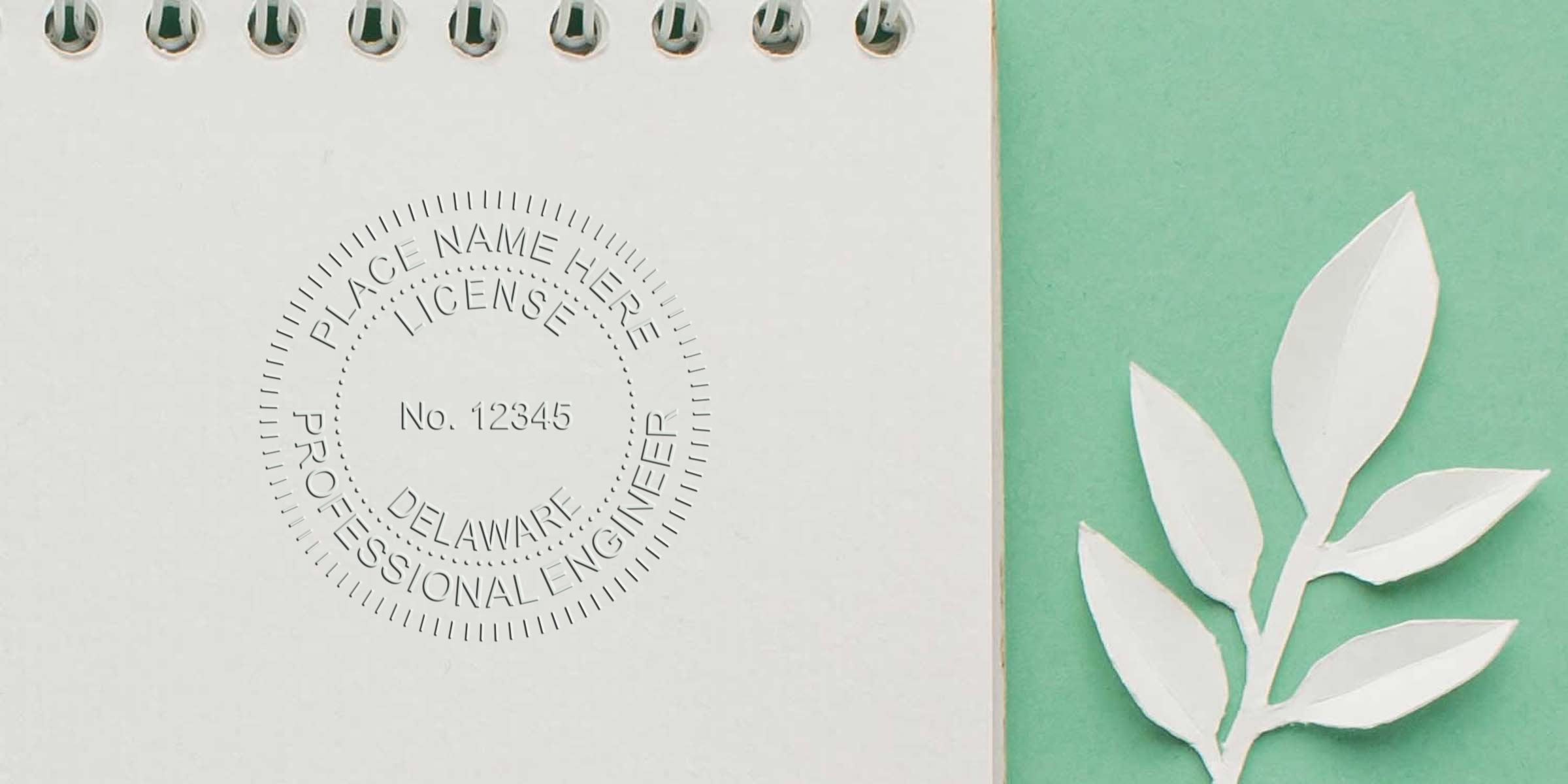 Embossed Delaware professional engineer license seal on white paper with green background and paper leaves, showing Delaware engineer seal requirements and guidelines.