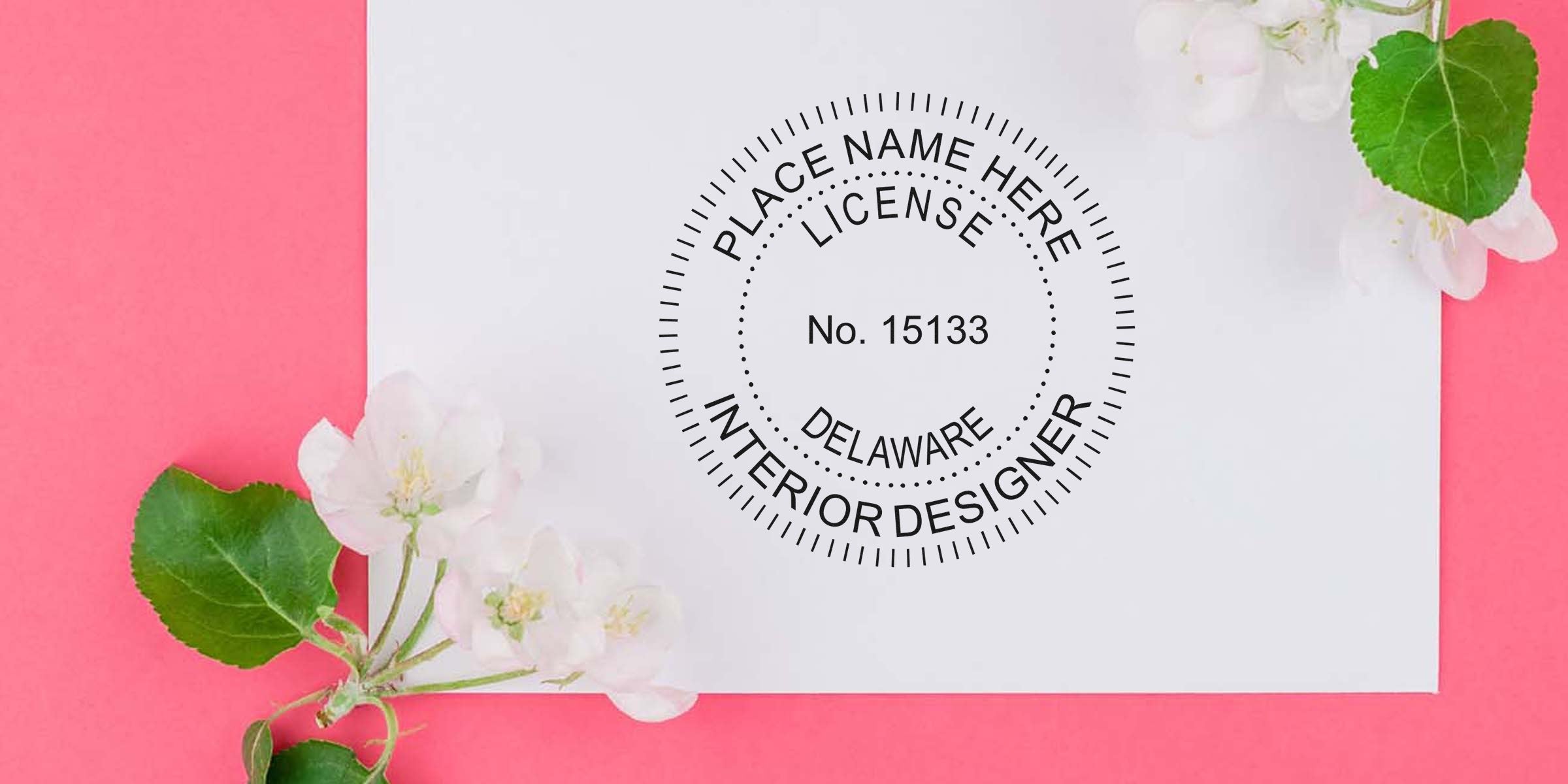 Delaware interior designer license stamp on white paper with flowers on pink background, highlighting Delaware interior designer stamp cost and fees.