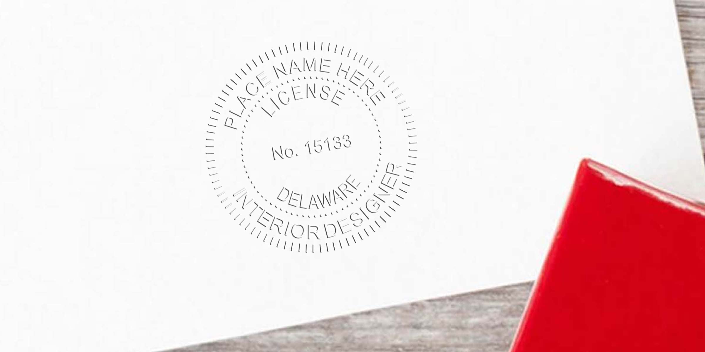Interior Designer Seal Delaware embossed on white paper with a red stamp on wood, showcasing the value of interior designer certification.