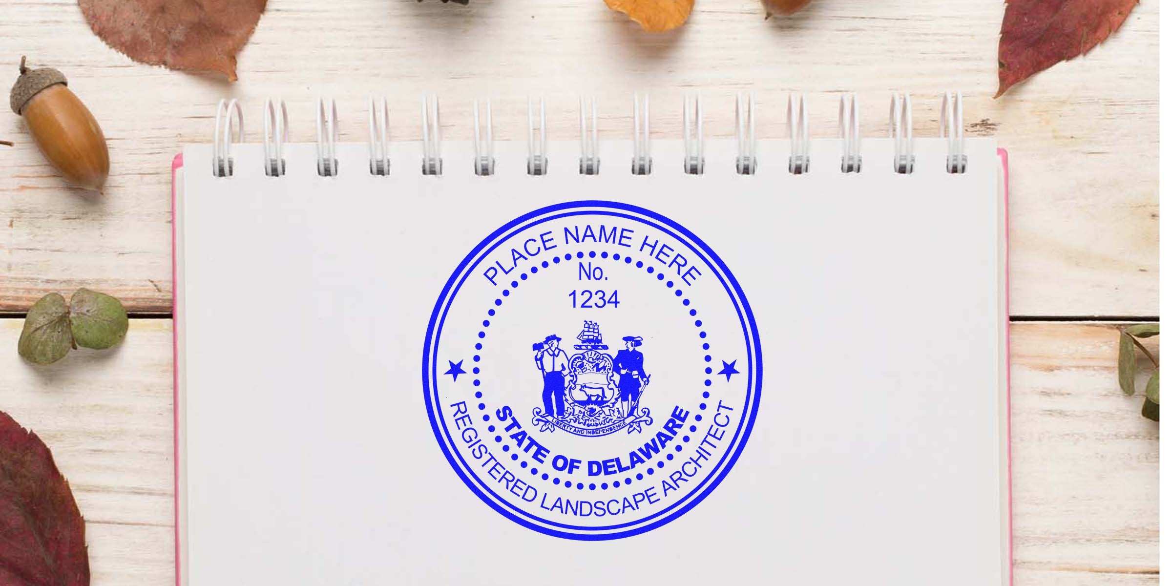 Delaware landscape architect stamp on notebook with autumn leaves and acorns, featuring the State of Delaware registered landscape architect seal meeting all seal requirements.