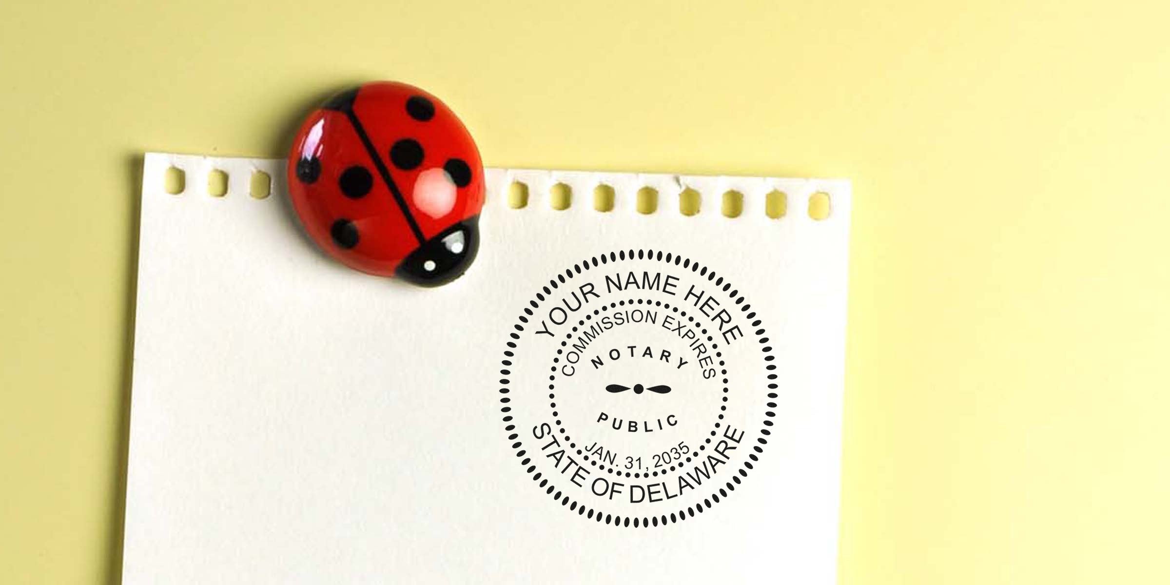 Delaware notary stamp on paper with a ladybug magnet, using a self-inking notary stamp.
