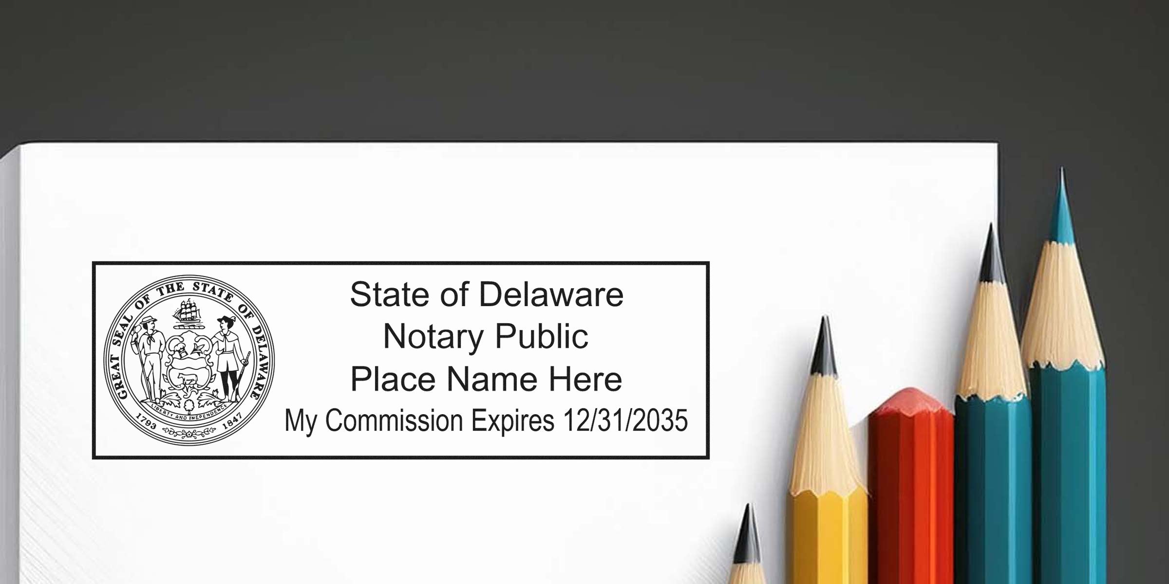 Delaware notary public commission certificate with DE notary stamp and colored pencils on gray background, showing essential Delaware notary supplies.