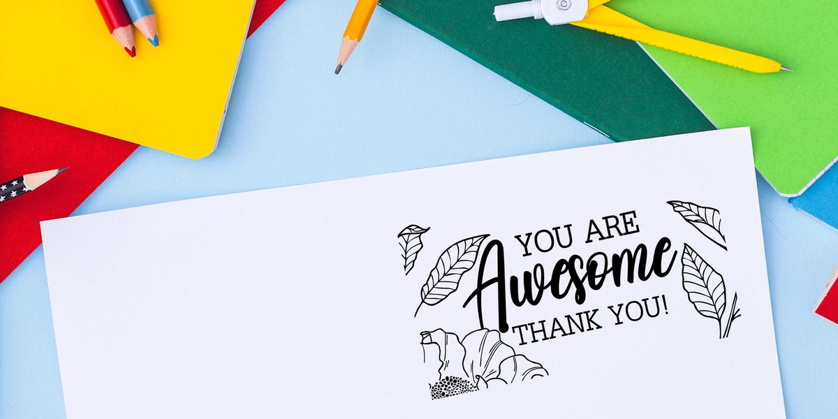 Colorful stationery with pencils and notebooks surrounding a thank you card that says “You Are Awesome Thank You” on a light blue background