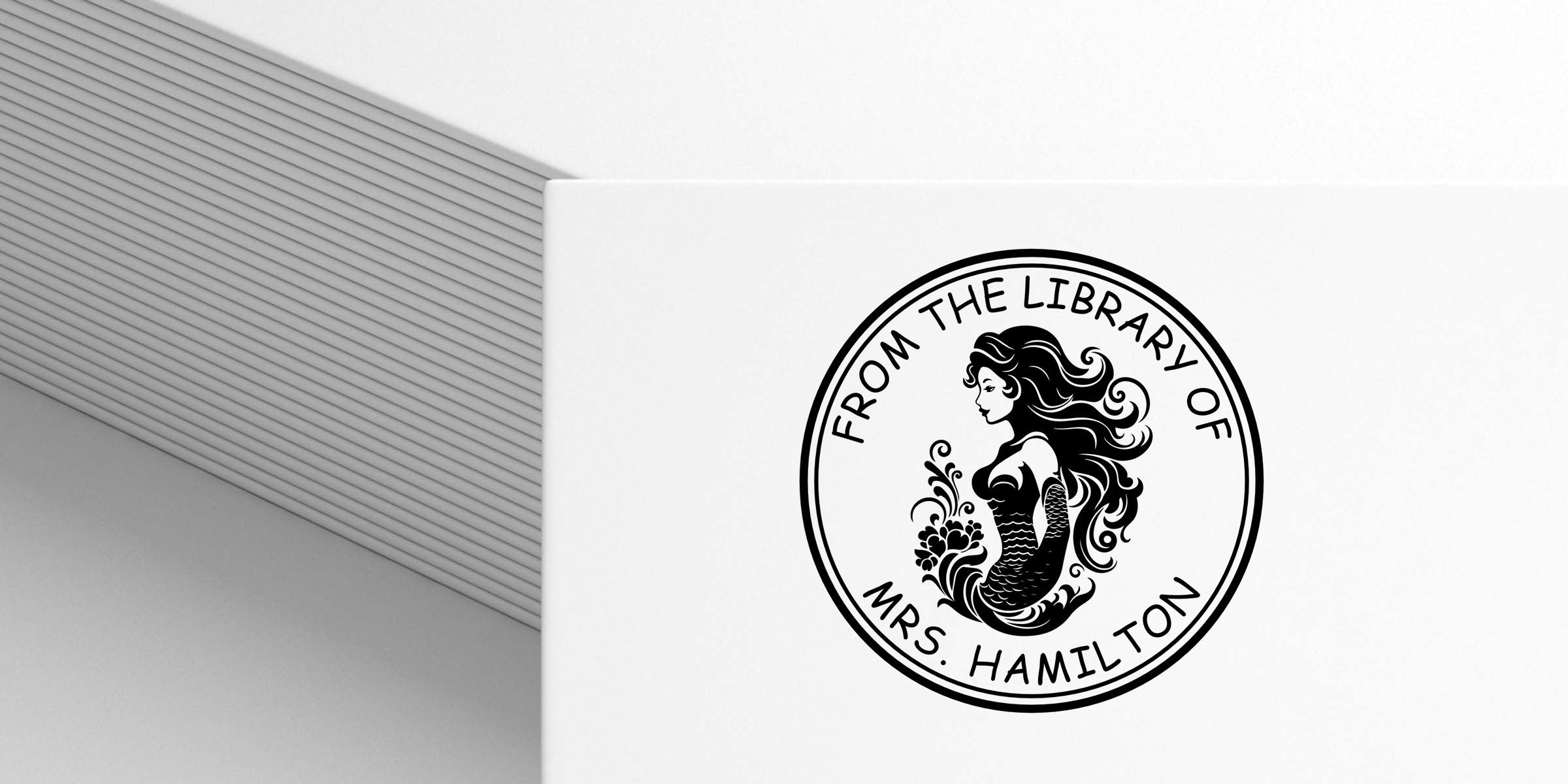 Custom bookplate featuring a mermaid logo with the text “From the Library of Mrs. Hamilton” on a white notebook cover